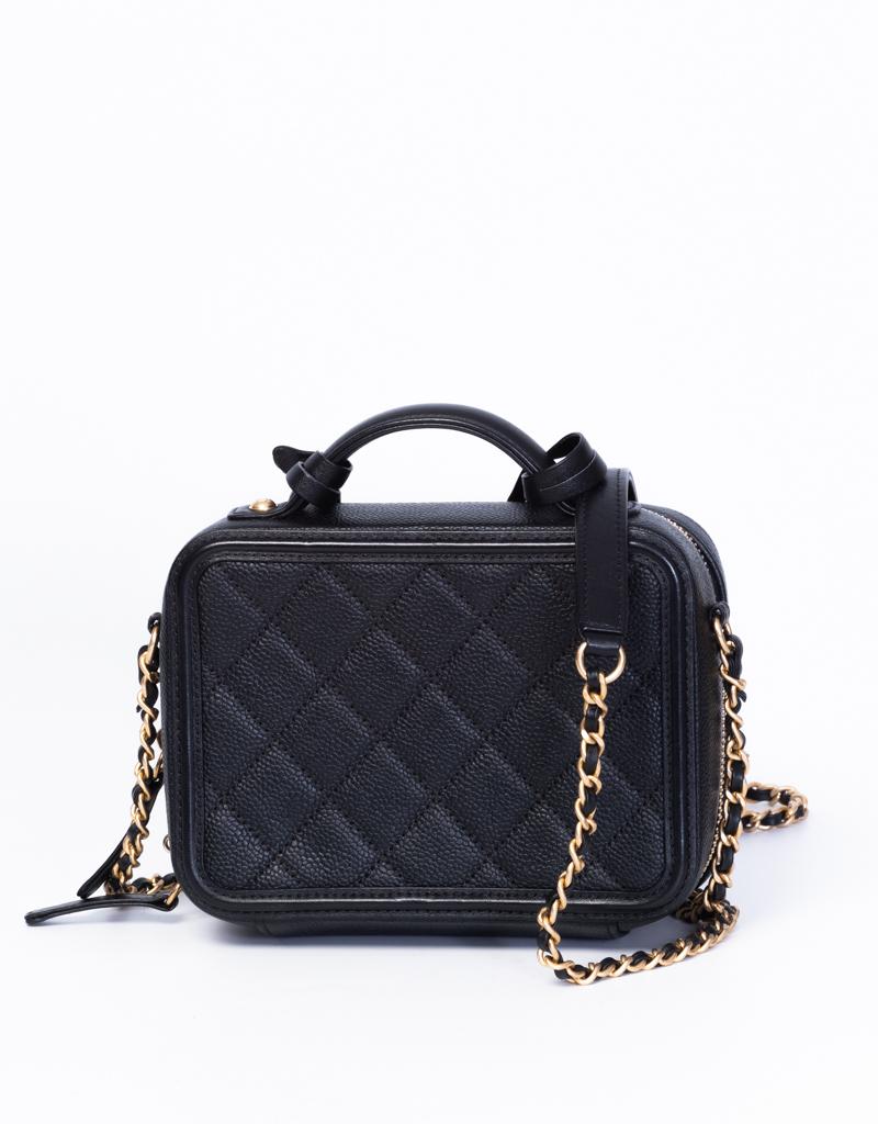 This Chanel CC Filigree Vanity Case is made with black quilted caviar leather. Featuring gold toned hardware, an embroidered CC at the front face, a gold toned chain interlaced with leather, a single top handle, and leather interior lining with two