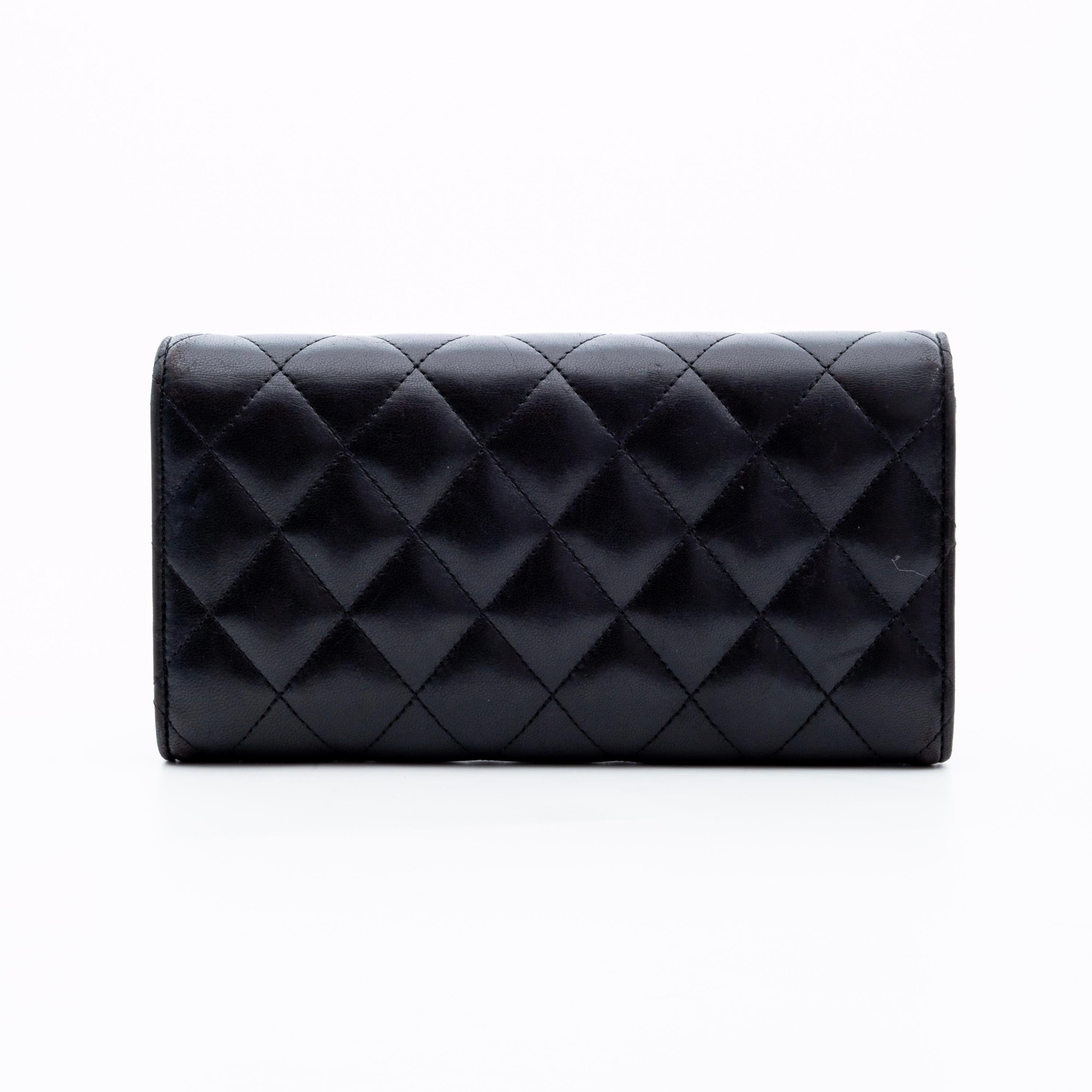 This wallet is made of luxurious, soft and supple lambskin leather in black with diamond quilted stitching. The wallet features a front flap with a small silver CC logo, snap closure, burgundy woven fabric lining and a partitioned interior with bill