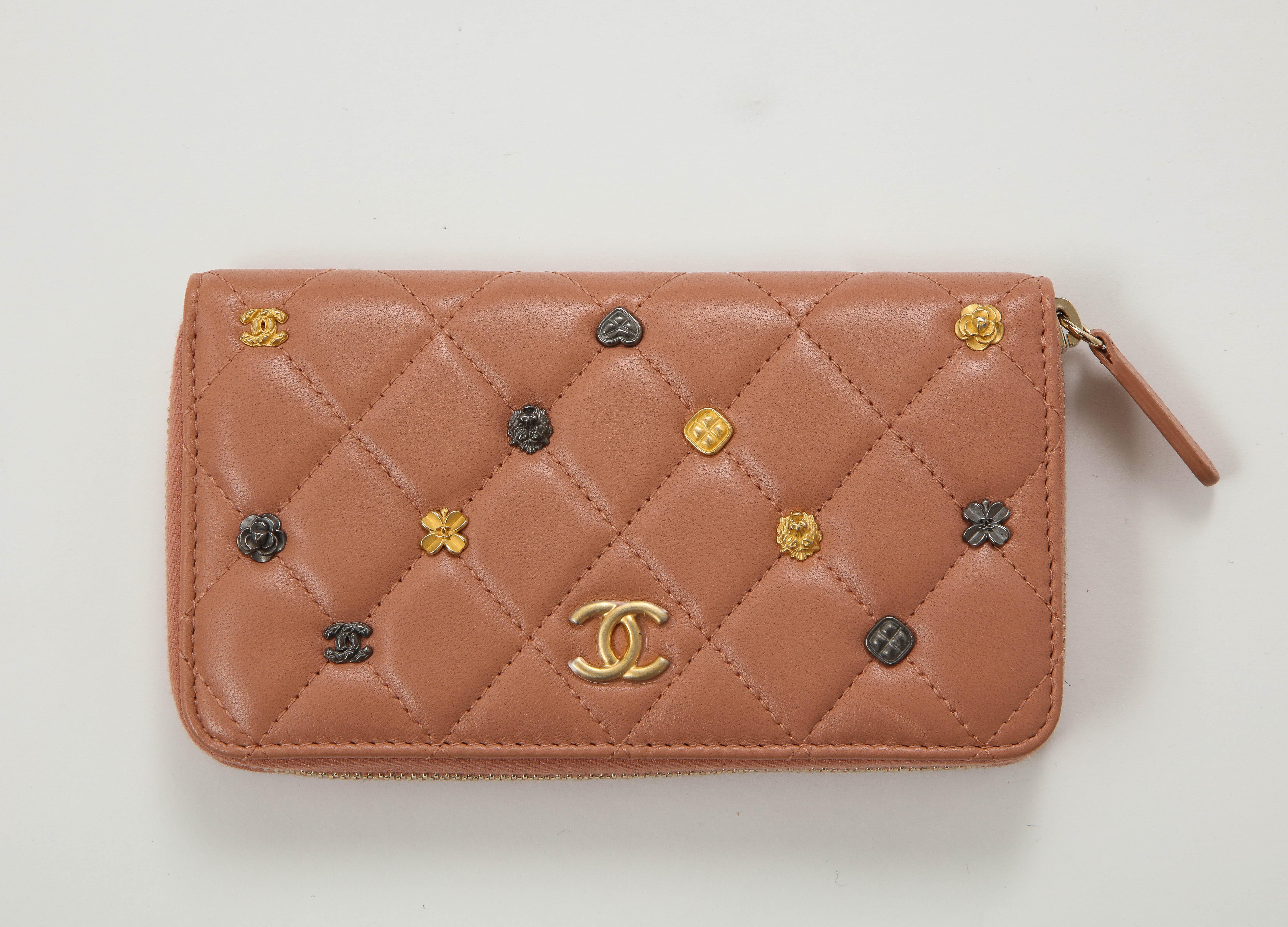 Ikonische gesteppte Brieftasche mit Rautenmuster aus rosafarbenem Lammleder mit Miniatur-Chanel-Charmen auf der Vorderseite. 2 Fächer mit einer mittleren Reißverschlusstasche. Neu, nie getragen, kommt mit Box und Aufbewahrungstasche.