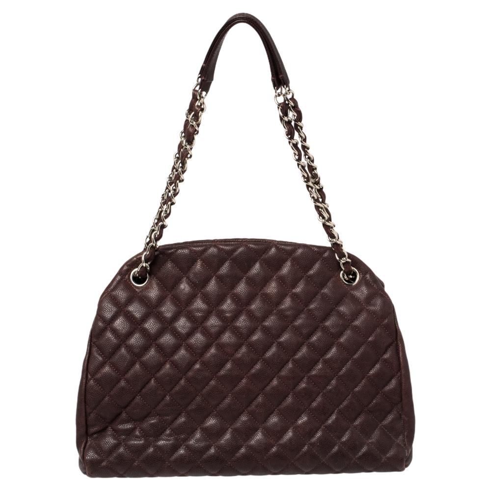 Spacious and lovely, this Just Mademoiselle Bowler bag is from Chanel. It has been crafted from black Caviar leather in their signature quilt pattern and enhanced with silver-tone hardware. It is equipped with chain handles and fabric compartments.