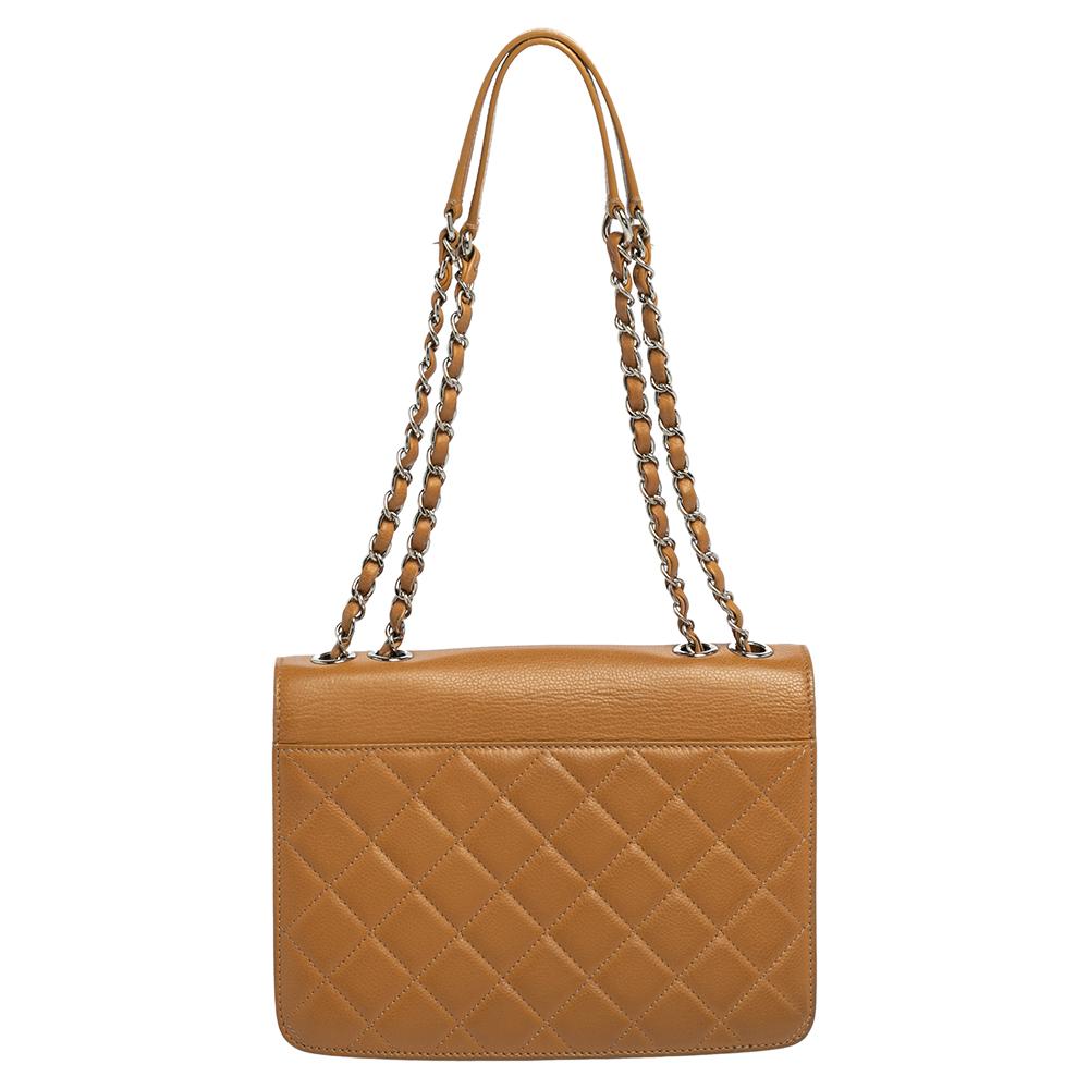 This Chanel box flap bag is the perfect accessory to dress up any outfit while remaining classy and minimalist at the same time. Crafted from beige quilted caviar leather, this small CC bag, with silver-tone hardware, shoulder straps, and a fabric