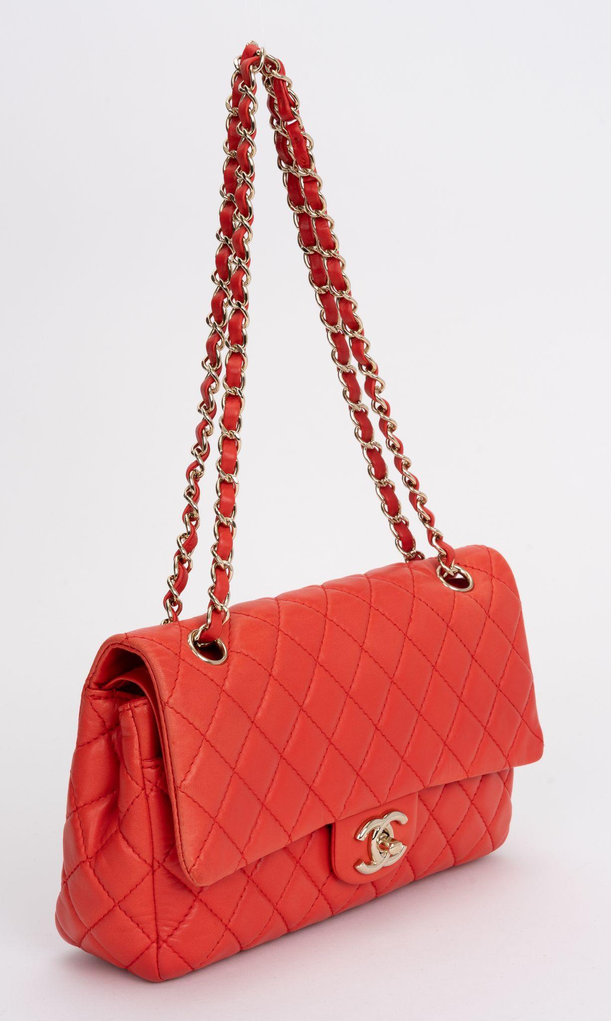 Le sac à rabat classique matelassé rouge de Chanel en cuir d'agneau est doté d'une bandoulière en cuir à chaîne entrelacée et d'une fermeture à logo CC doré. Il y a une poche zippée à l'intérieur et une pochette arrière à l'extérieur.

Chute