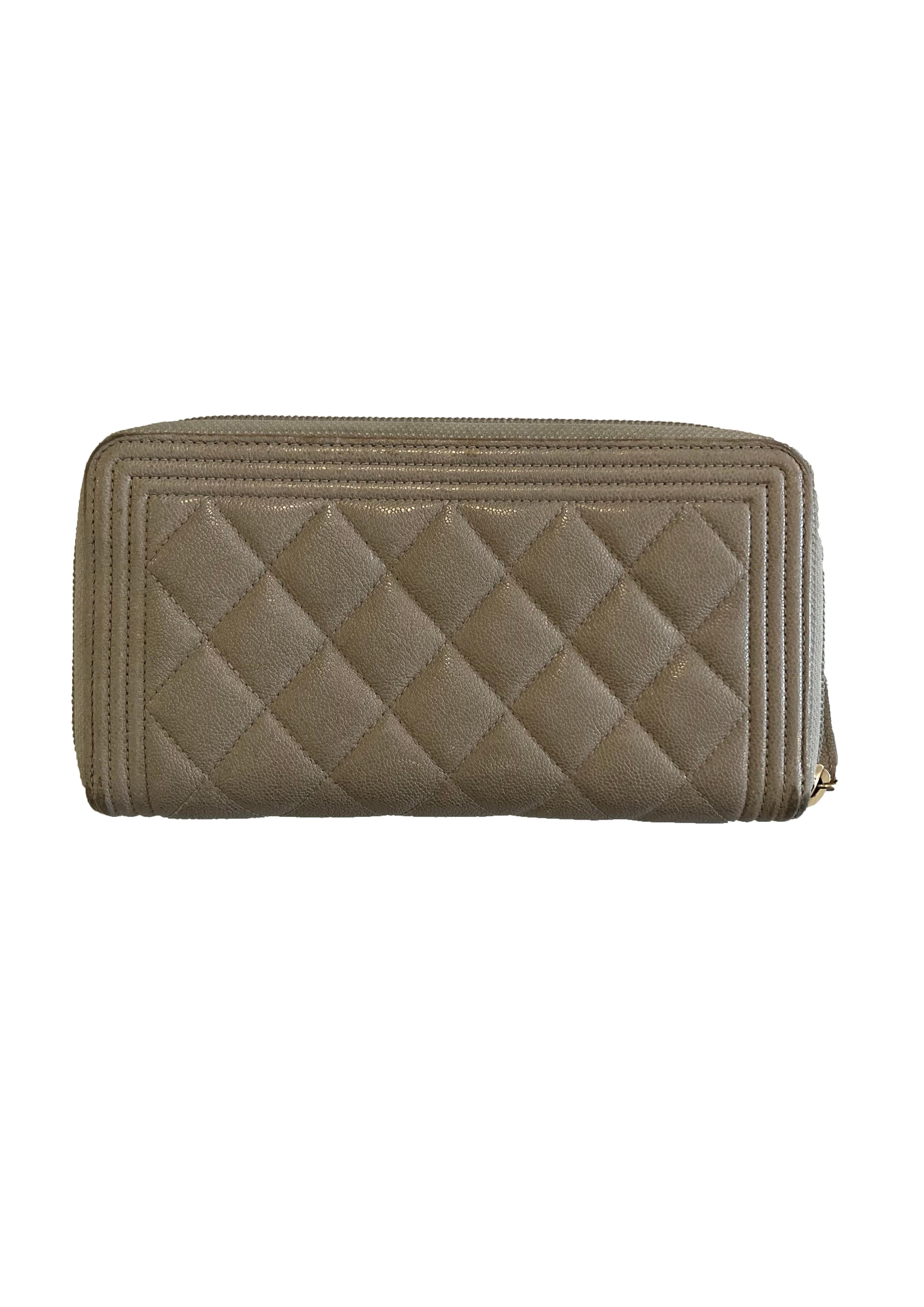 Light grey quilted leather Classique purse from Chanel. With matte gold toned metal plaque carrying interlocking C logo. Zips open with a leather zip pull to reveal interior lined in grey leather and canvas, with one zipped compartment, 8 card