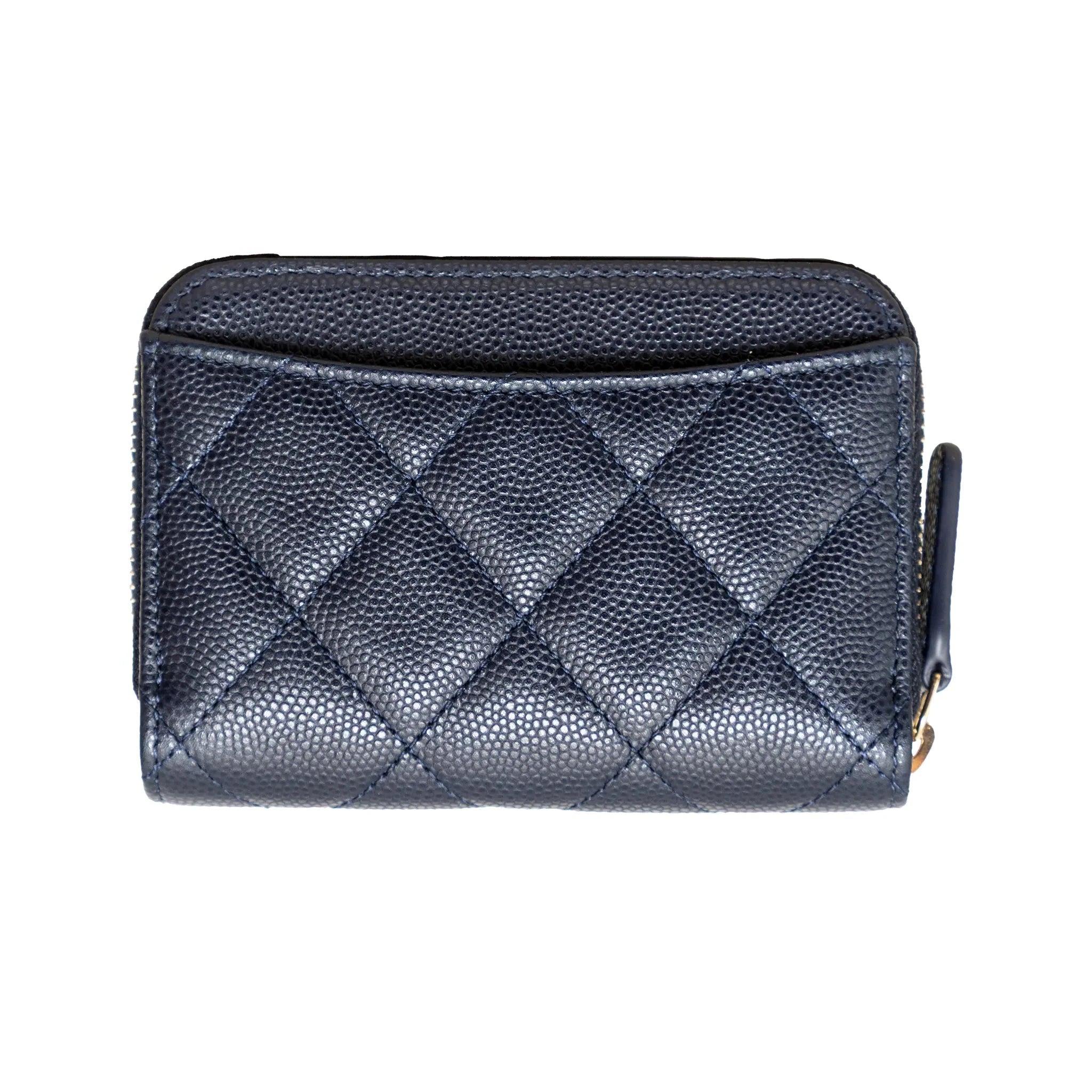 Monedero Chanel de la colección Crucero 2023, en piel de caviar acolchada azul marino, herrajes dorados, colgantes de corazón y pala, cremallera superior, 3 compartimentos y bolsillo trasero. 
 Incluye: bolsa guardapolvo, caja. 
 Material: Piel 
