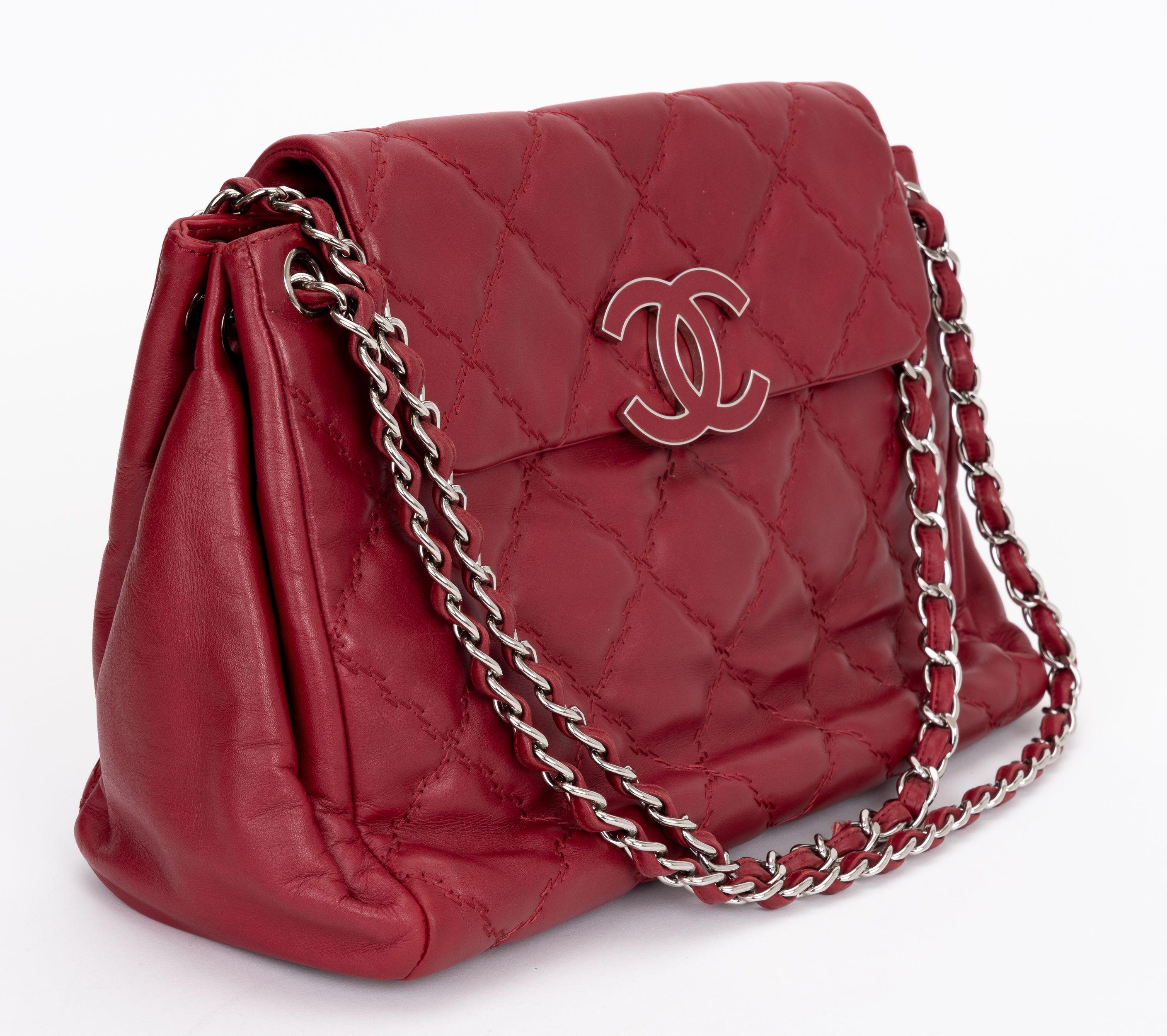 Chanel Quilted Hampton Flap Tote in pelle di vitello rossa con dettagli trapuntati a doppio punto. La borsa è dotata di una lunghissima tracolla in pelle con catena argentata e logo Chanel CC. La patta frontale si apre con un bottone a pressione per