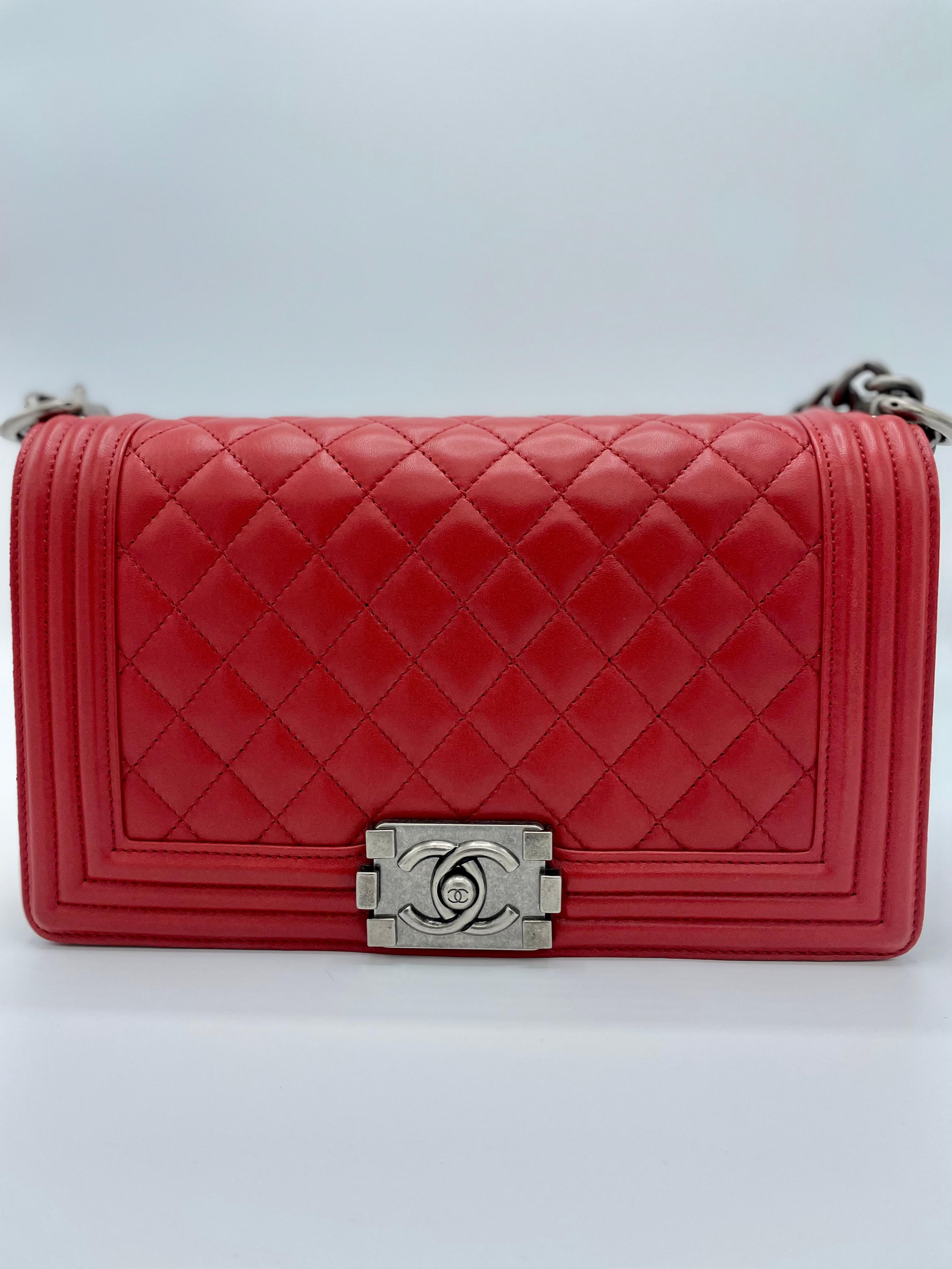 Chanel Quilted Lambskin Boy Flap Bag Red. In perfect condition. This 2014-2015 version has a leather and chain-link shoulder strap with an adjustable buckle, a push-lock closing, and an inside slide pocket surrounded by silver hardware. This medium