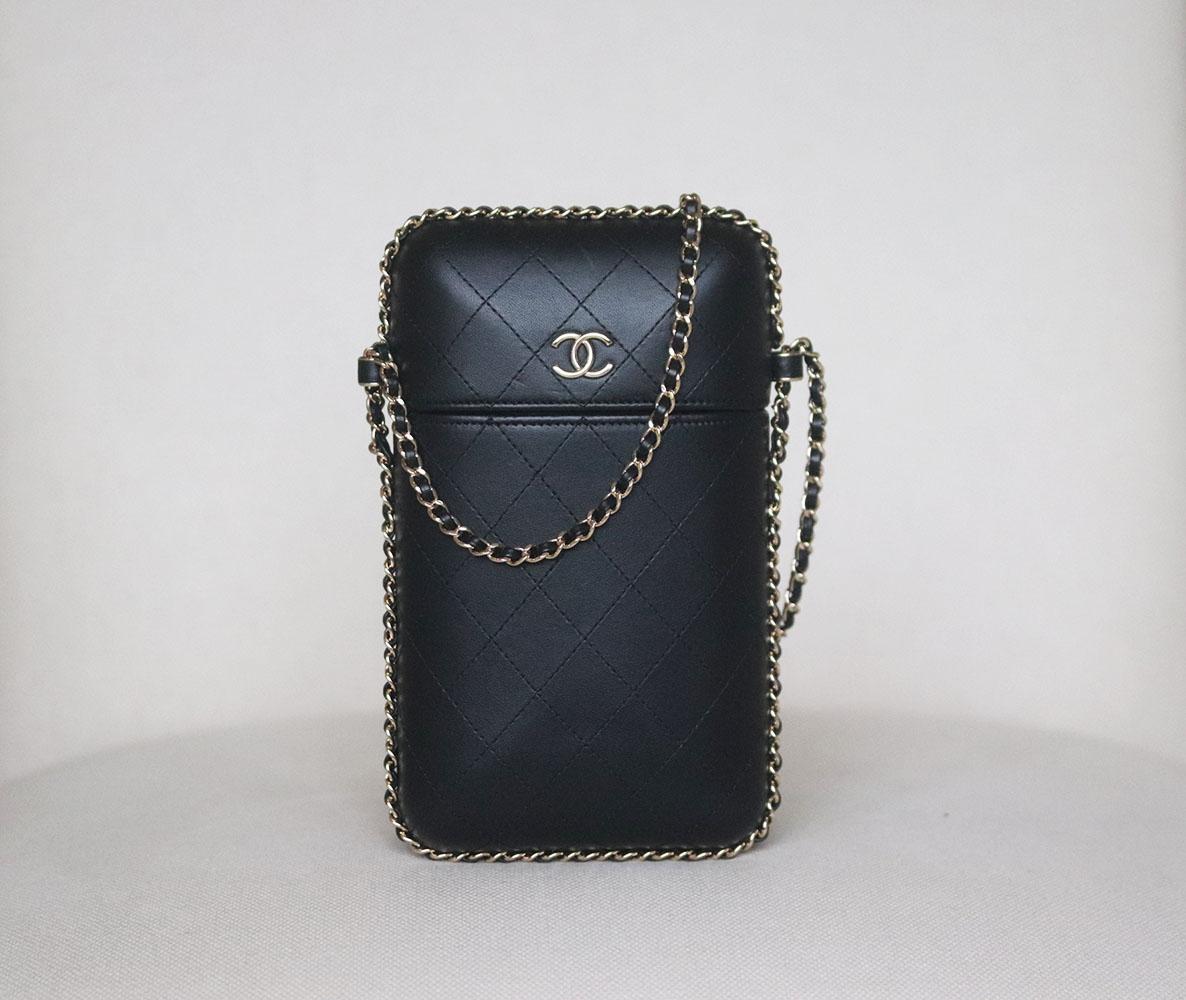 Chanel Quilted Lambskin Chain Around Phone Holder Bag has been hand-finished by skilled artisans in the label's workshop, it is boasting a black quilted lambskin exterior, this design is accented with silver-toned and black lambskin-leather chain
