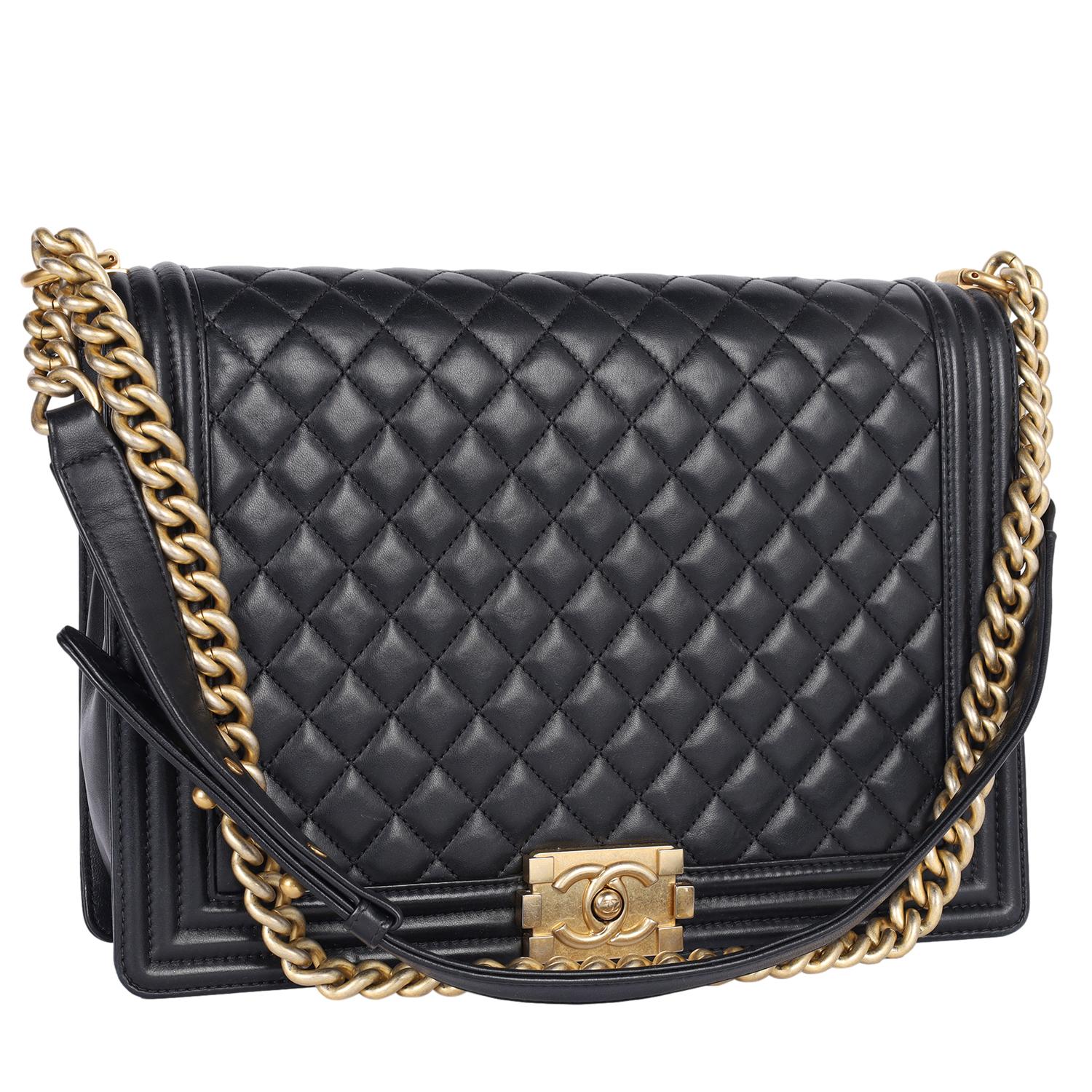 Authentic Chanel Lambskin Quilted Large Boy Flap Black. Features black soft diamond quilted leather, aged gold chain, shoulder strap with a leather shoulder pad that is adjustable, aged gold Mademoiselle press lock closure. The bag opens  to a black