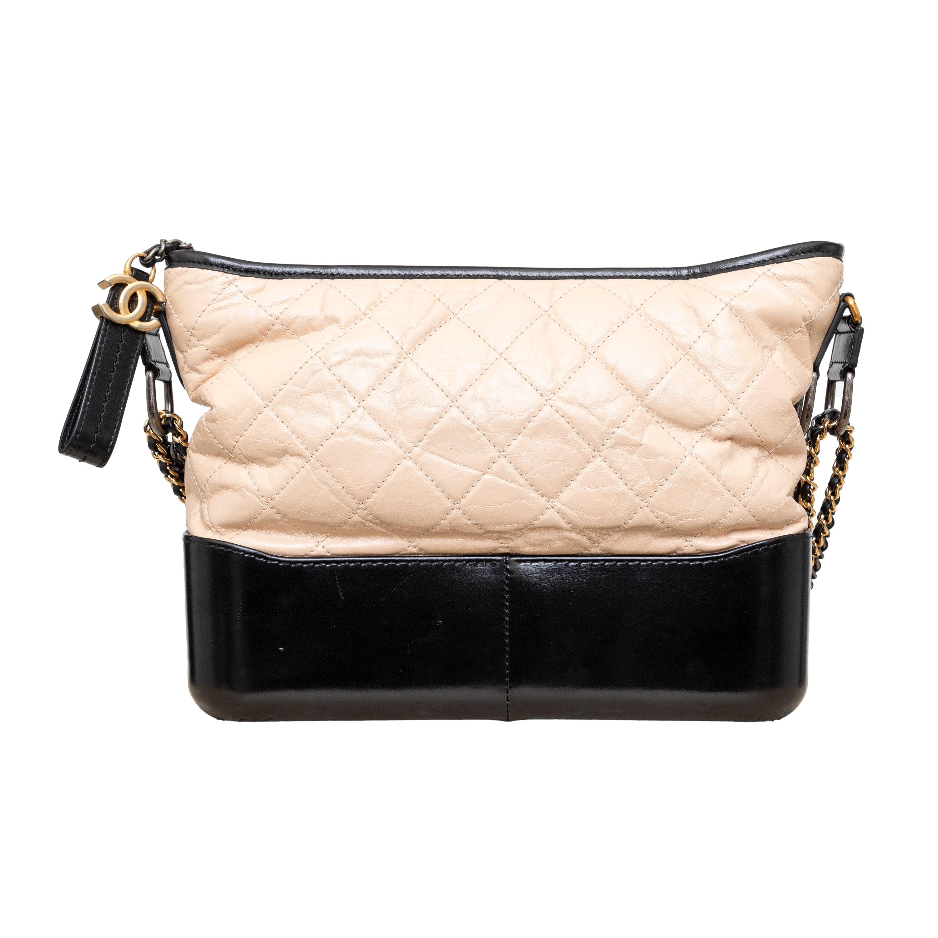 The Chanel Quilted Large Gabrielle Hobo Bag is the epitome of chic and sophisticated style. Crafted with high-quality calfskin leather, this hobo bag features a quilted design in beige with black trimming, complemented by a gold to ruthenium chain