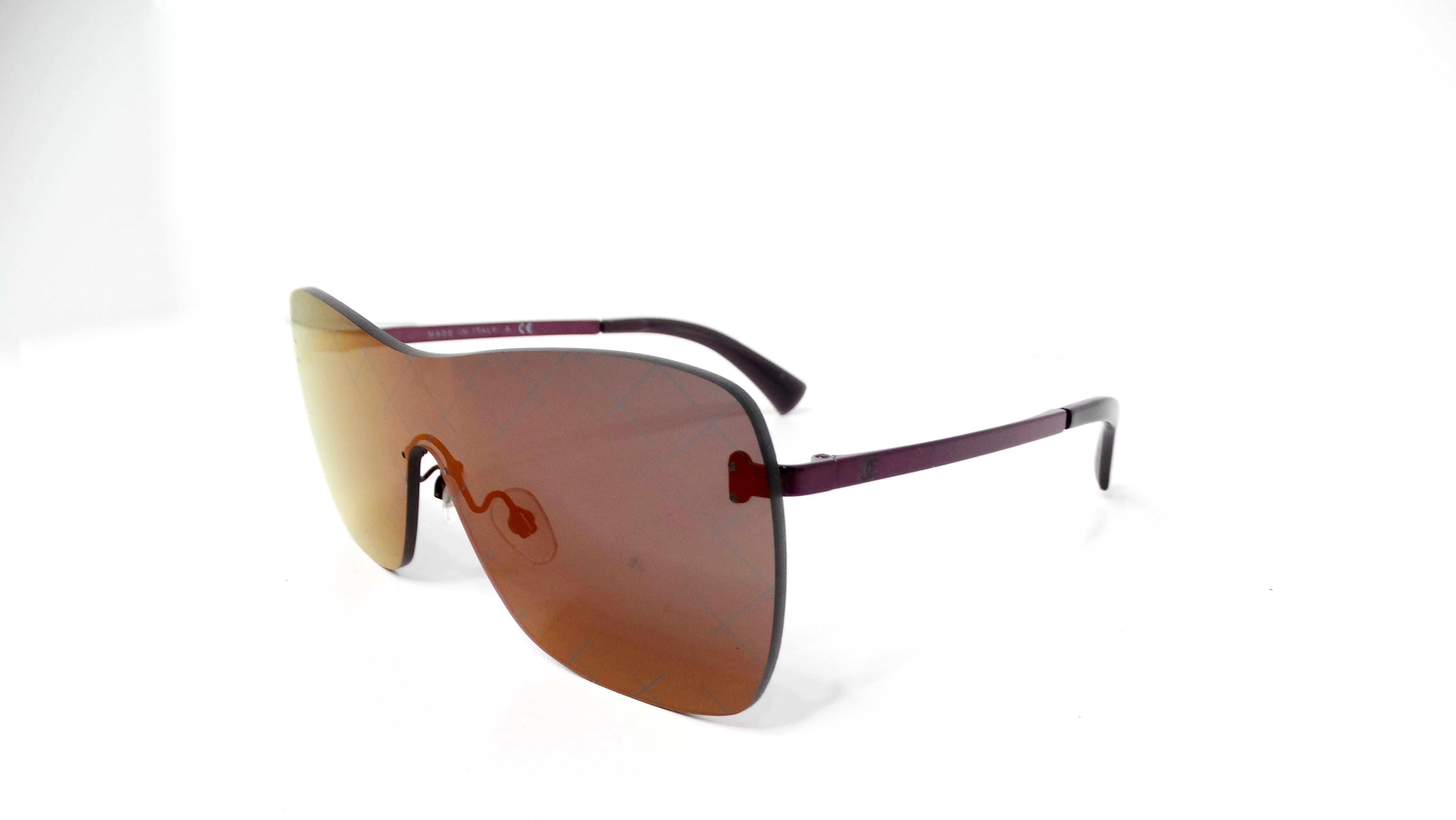 Gli occhiali da sole Chanel Quilted Reflective Mirrored Lens Shield incarnano l'iconica eleganza del marchio unita a un tocco moderno. Caratterizzati da raffinate aste in metallo e lenti riflettenti color tramonto, questi occhiali da sole sono