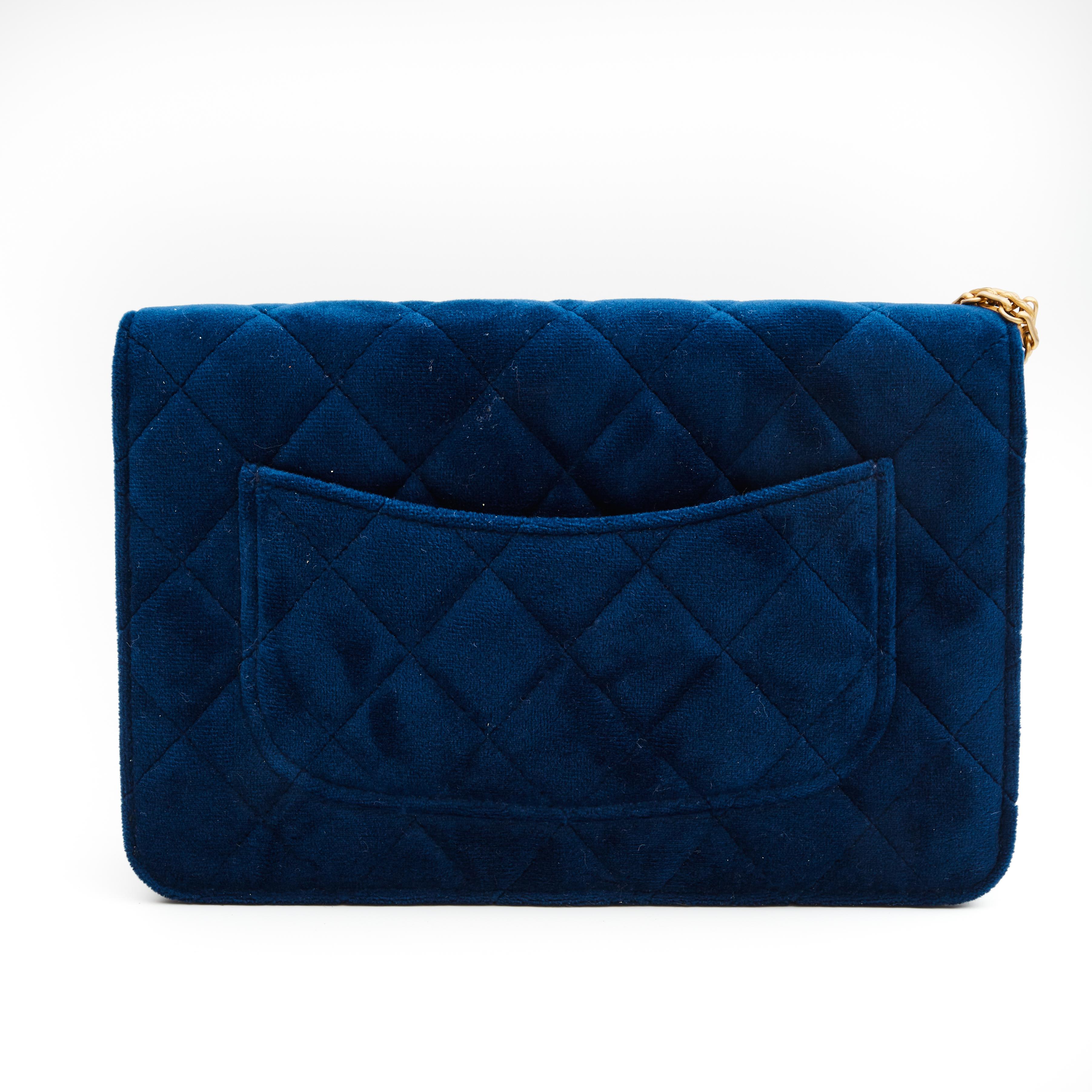 This wallet on a chain bag is made of diamond quilted velvet in blue. The bag features an aged gold bijoux chain shoulder strap, a squared Mademoiselle turn lock closure and a blue leather interior with a zip pocket, slip pocket and many card slots.