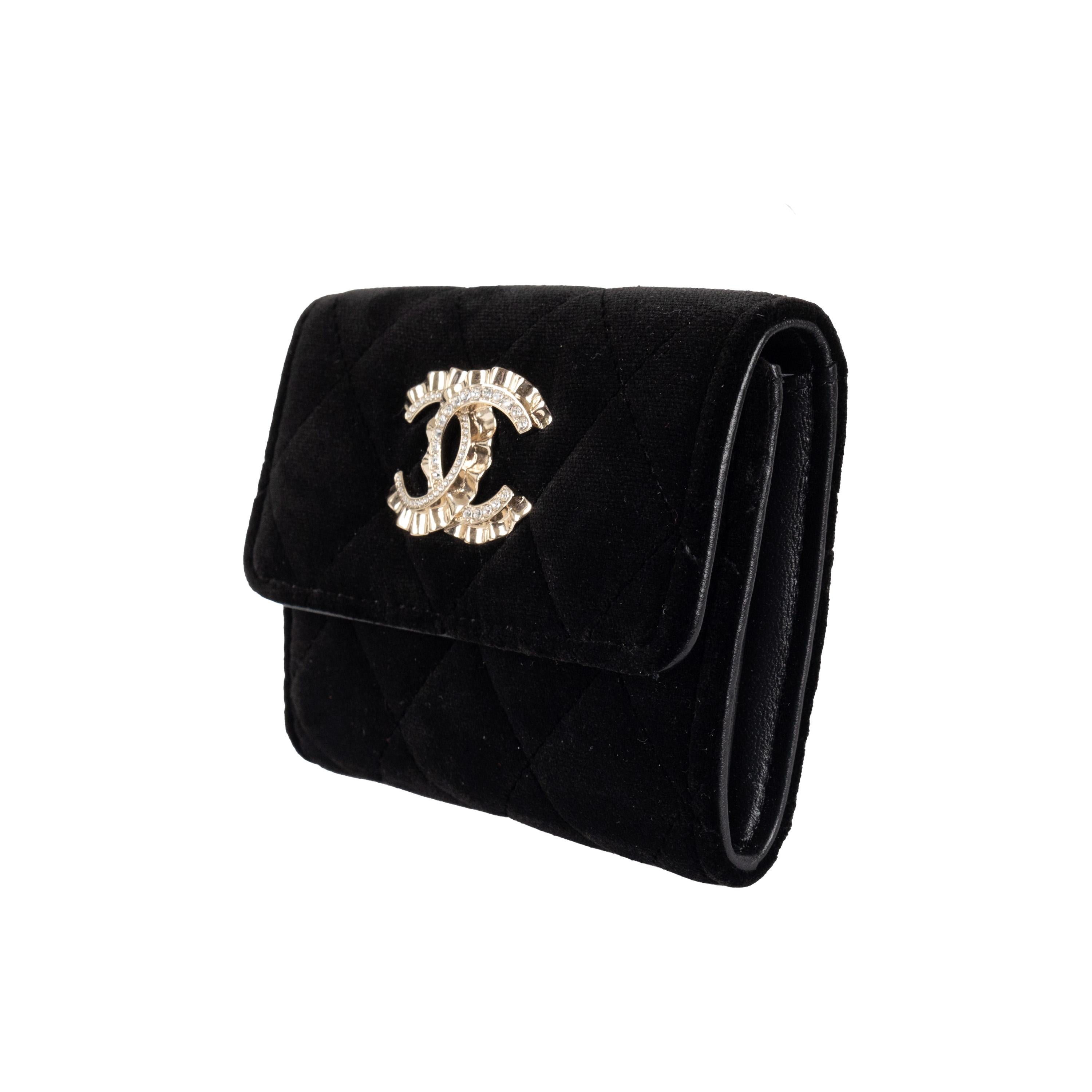 Expertly crafted from luxurious black velvet, this Chanel quilted wallet is the epitome of elegance and sophistication. The iconic CC snap button closure, adorned with sparkling crystal stones, adds a touch of glamour to this essential