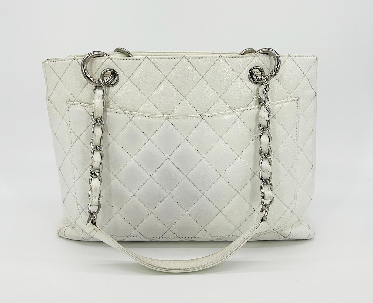 Chanel Quilted White Caviar Grand Shopper Tote in fair condition. Quilted white caviar leather exterior trimmed with silver leather and siganture CC Chanel logo along front side and back slit pocket. Woven chain and leather shoulder strap handle