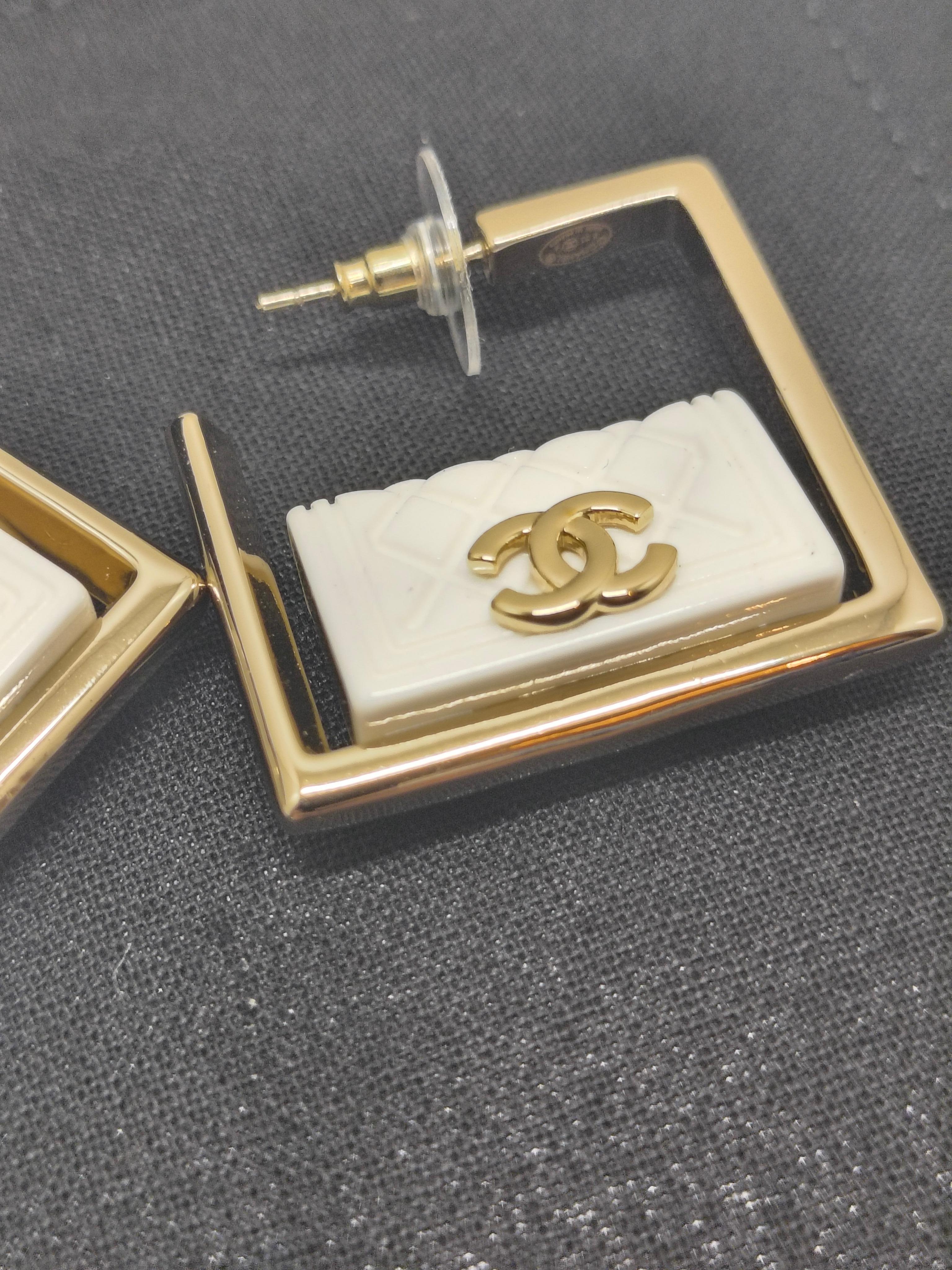 Orecchini a cerchio quadrati con smalto bianco trapuntato di Chanel - Collezione B25

L'eleganza moderna incontra il classico charme Chanel in questi caratteristici orecchini a cerchio quadrati della Collection'S B25. Caratterizzati da un design