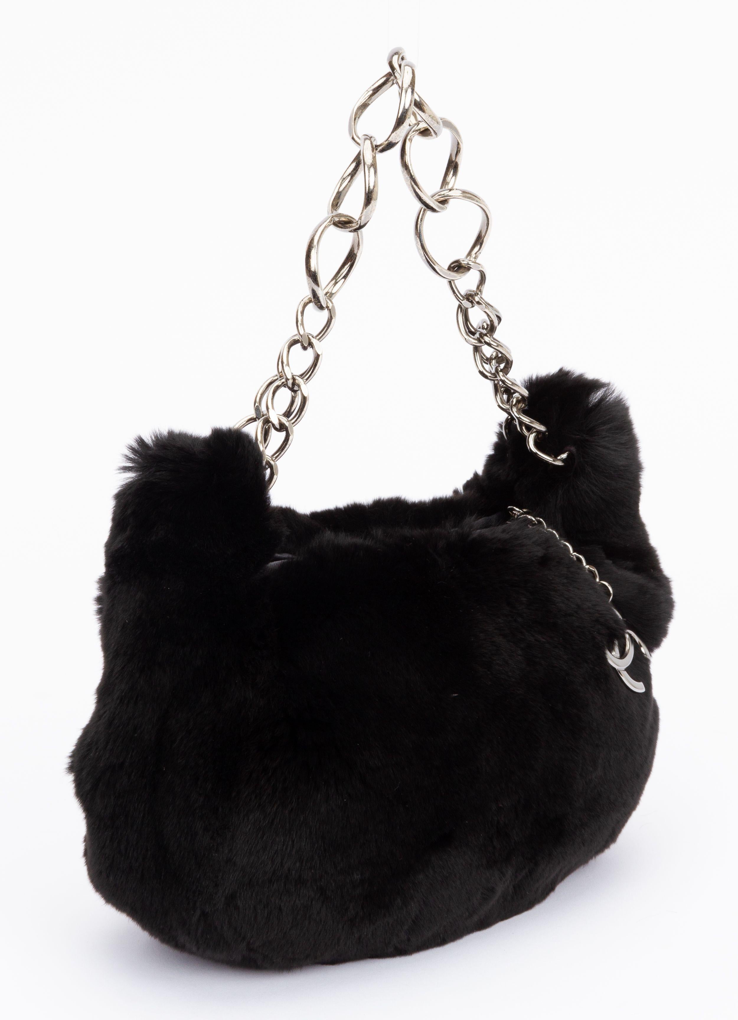 Chanel rabbit fur hobo in black. This hobo is crafted of plush rabbit fur. The bag features a silver chain link shoulder strap and a silver Chanel CC zipper pull. It opens to a Chanel CC fabric interior. The piece is in excellent condition and has
