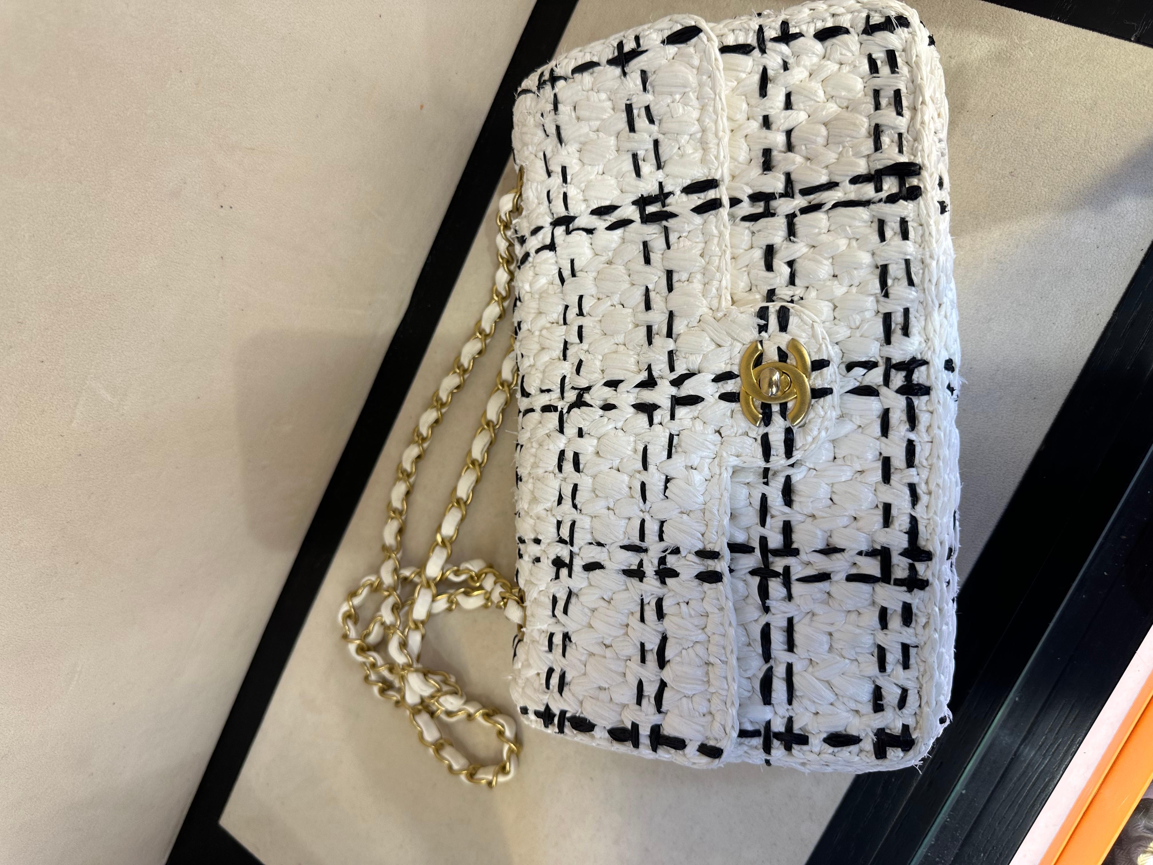 CHANEL Raffia Effect Tweed Braided Medium Flap in White and Black. 2023 spring summer Ready- to-wear collection. This chic bag is crafted of woven tweed. The bag features a gold chain-link shoulder strap threaded with ivory leather. The flap opens