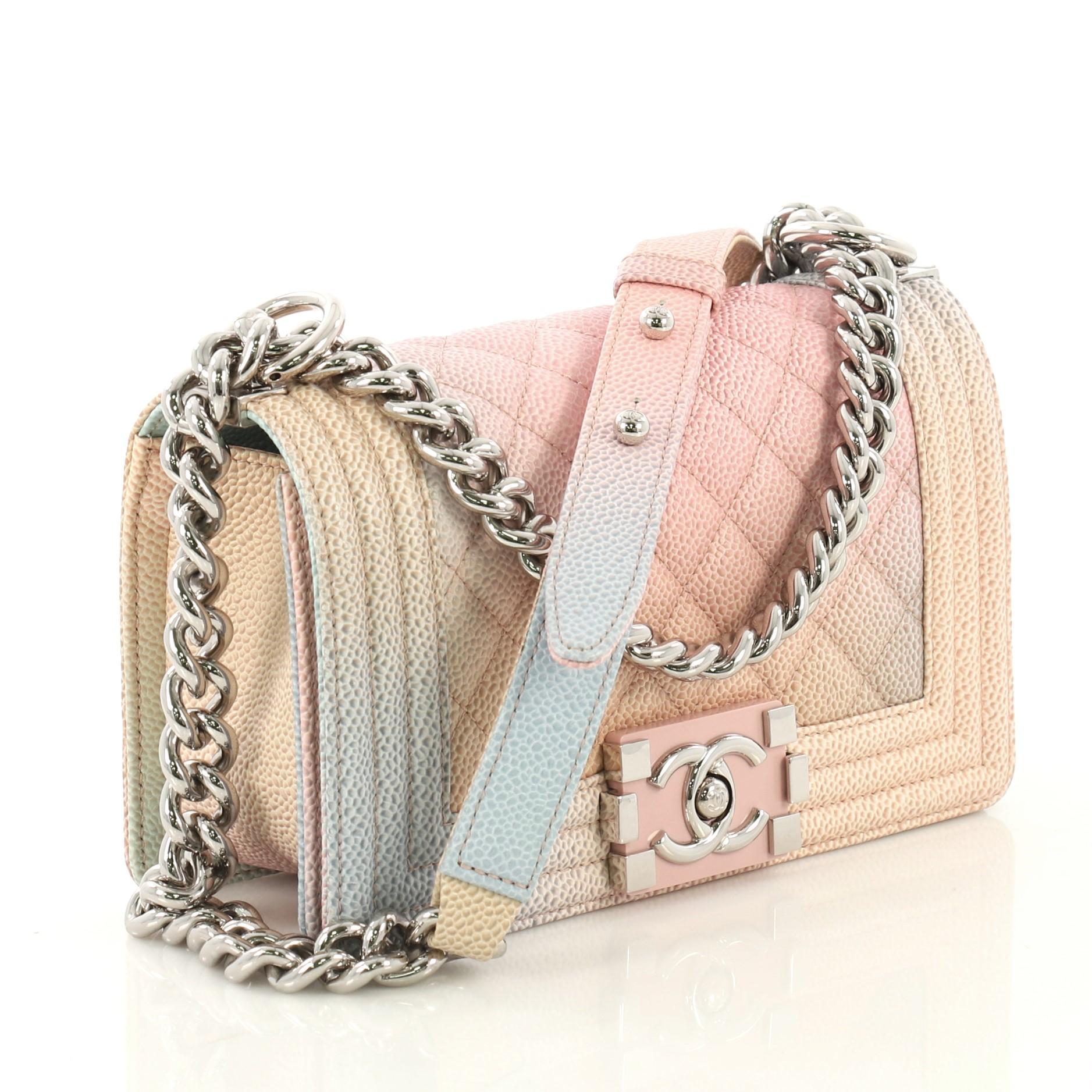 This Chanel Rainbow Boy Flap Bag Quilted Painted Caviar Small, crafted in multicolor quilted painted caviar leather, features chain link strap with leather shoulder pad and silver-tone hardware. Its boy push-lock closure opens to a pink fabric