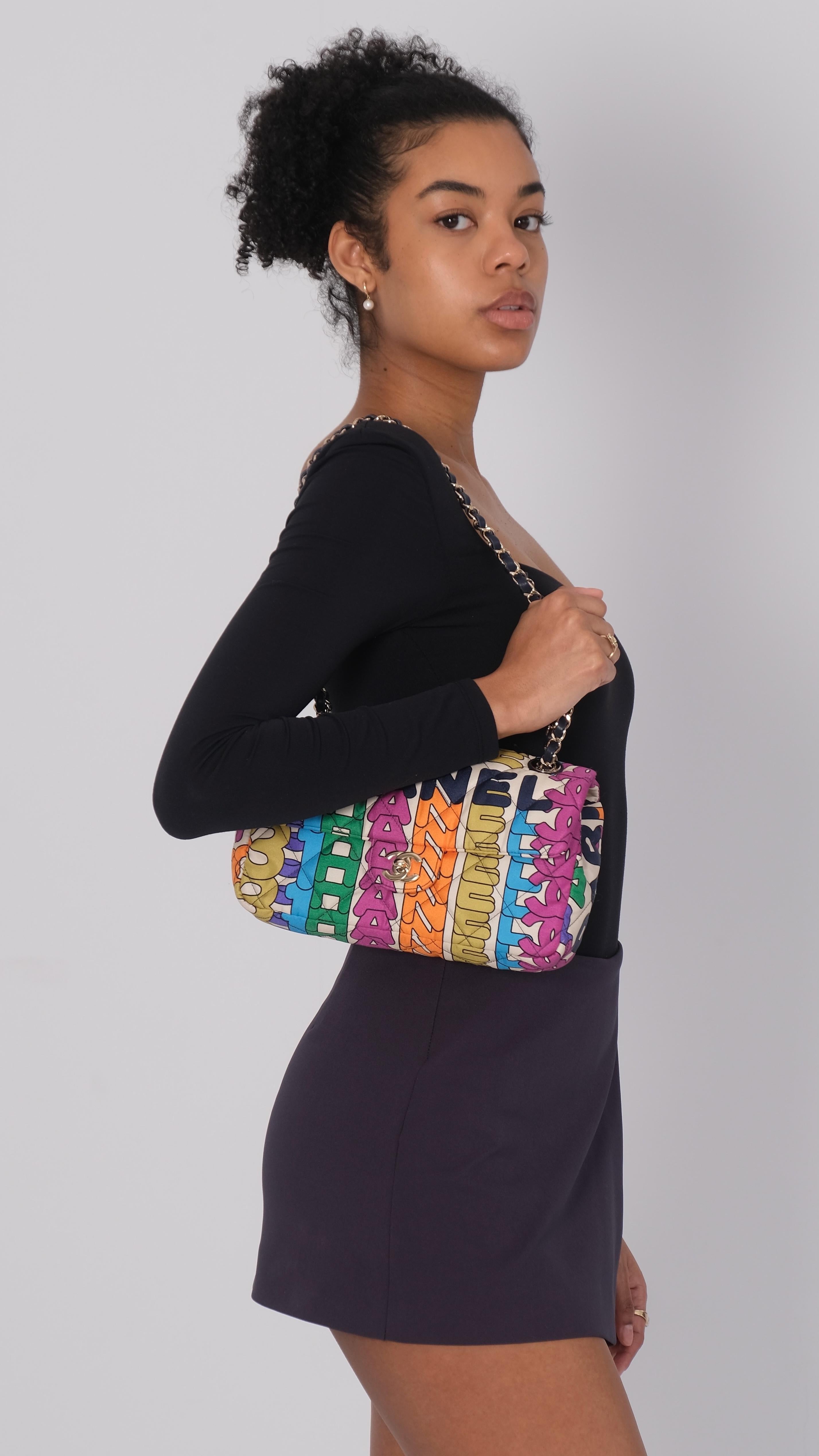 This bag is made of nylon quilted fabric. This bag features multicolor rainbow logo printed throughout, square pattern quilting, and a navy blue shoulder straps.

Authenticated by real Authentication. Category, retail.

Color: Multicolor
Material: