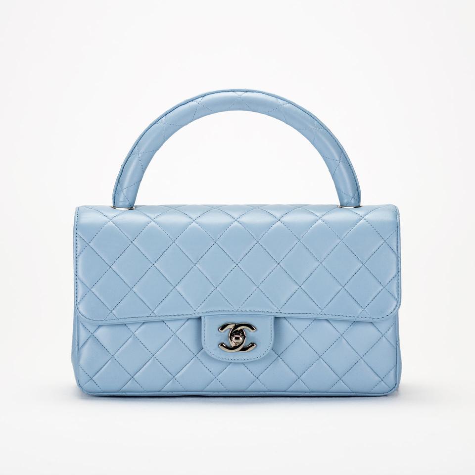 Baby blue Chanel lambskin quilted flap with top handle and classic back pocket

1996 {VINTAGE 26 Years}
Silver hardware
Classic turn lock CC closure
Interior center zippered pocket
Additional large interior pocket
Stitched interior cc logo on