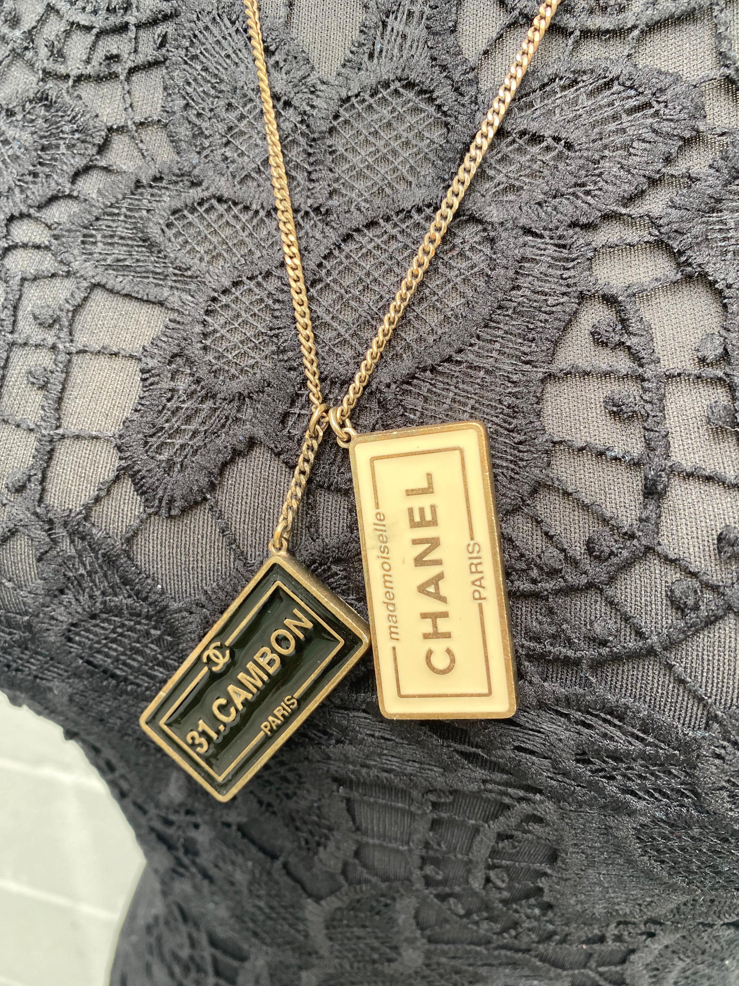 The timeless Chanel charm necklace makes this a fabulous fashion accessory. The black and white Chanel necklace features two dog tag charms embossed with reversed Chanel name logo on both sides. This is a unique necklace with the timeless quality