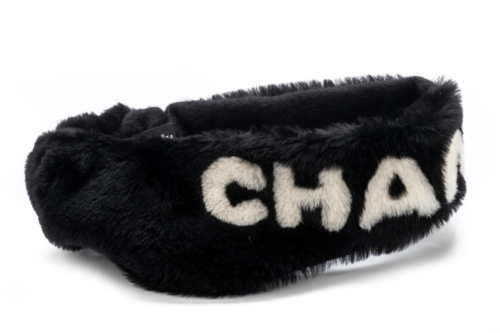 Chanel collectible and iconic black shearling headband with Chanel writing in white. Cashmere interior. Stretchy. Comes with original dust cover .