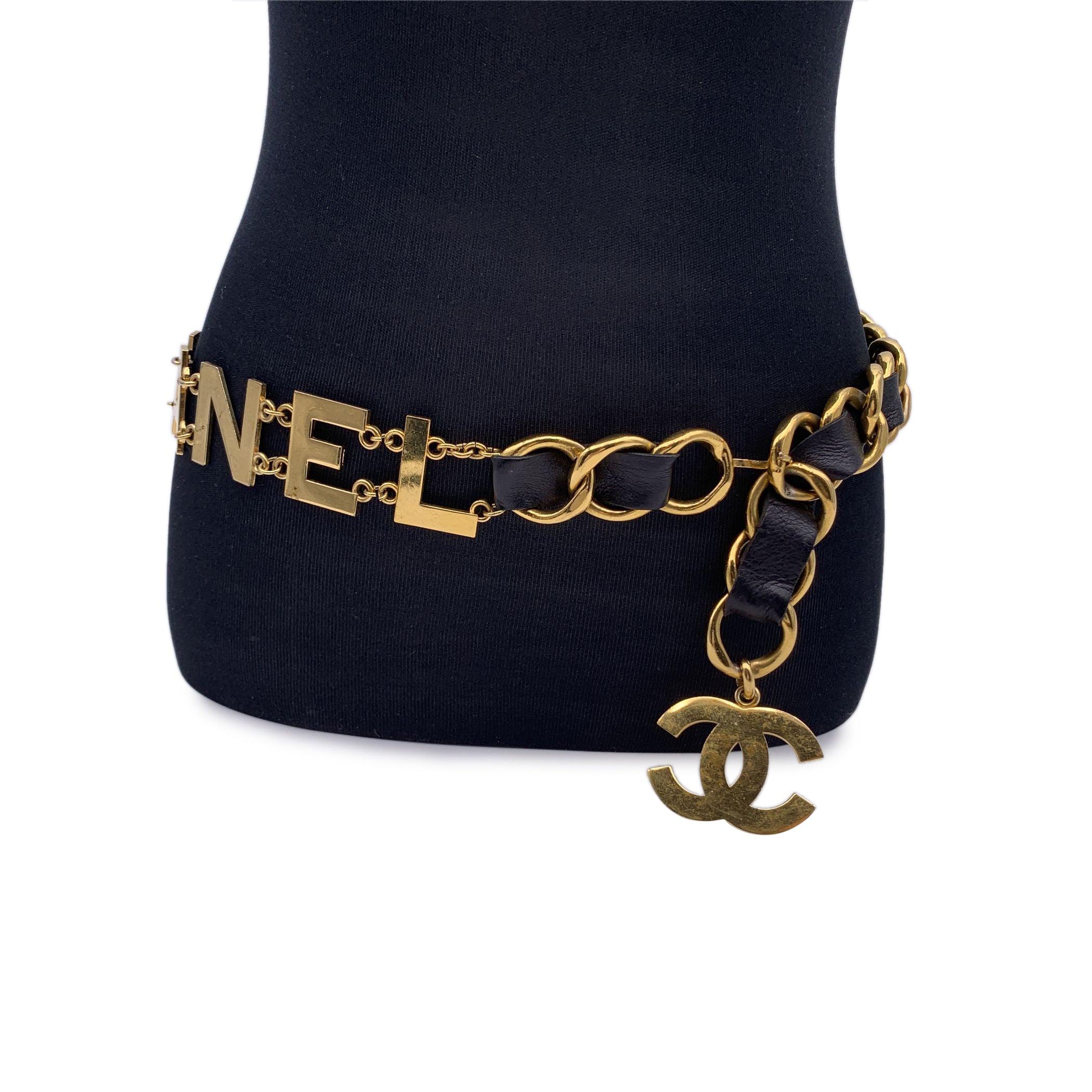 Rare statement vintage wide chain belt by CHANEL. Period/Era: 1993. It is crafted in gold metal with black interwoven leather. It features a spell out C O C O C H A N E L letters. CC logo pendant at theend of the belt. Hook closure. Marked with