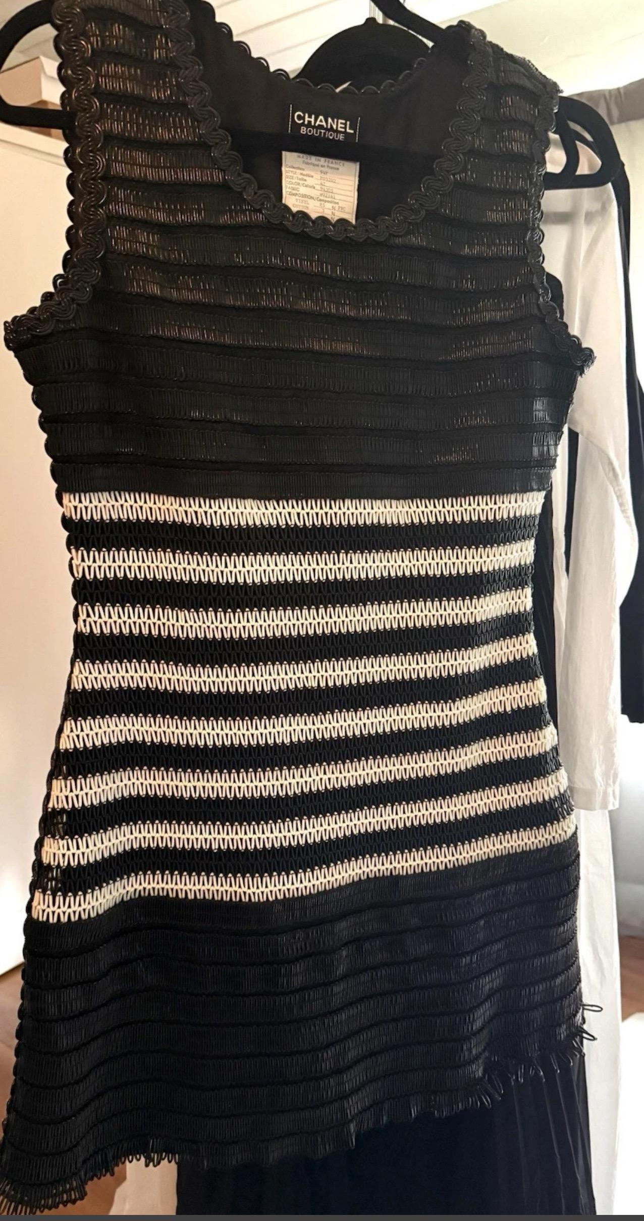 Une pièce à fort impact de la Collection S/One 1994 de Chanel, dessinée par Karl Lagerfeld. Cette étonnante mini robe noire et blanche est confectionnée en vinyle brillant de type raphia, avec des panneaux en PVC alternant des motifs audacieux de