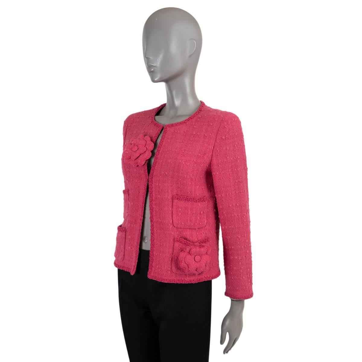 100% authentic Chanel tweed jacket in raspberry pink wool (90%), nylon (5%) and mohair (5%). Features a collarless, straight-cut silhouette with four open pockets on the front and adorned with two Camellias. Closes with concealed hooks and is lined