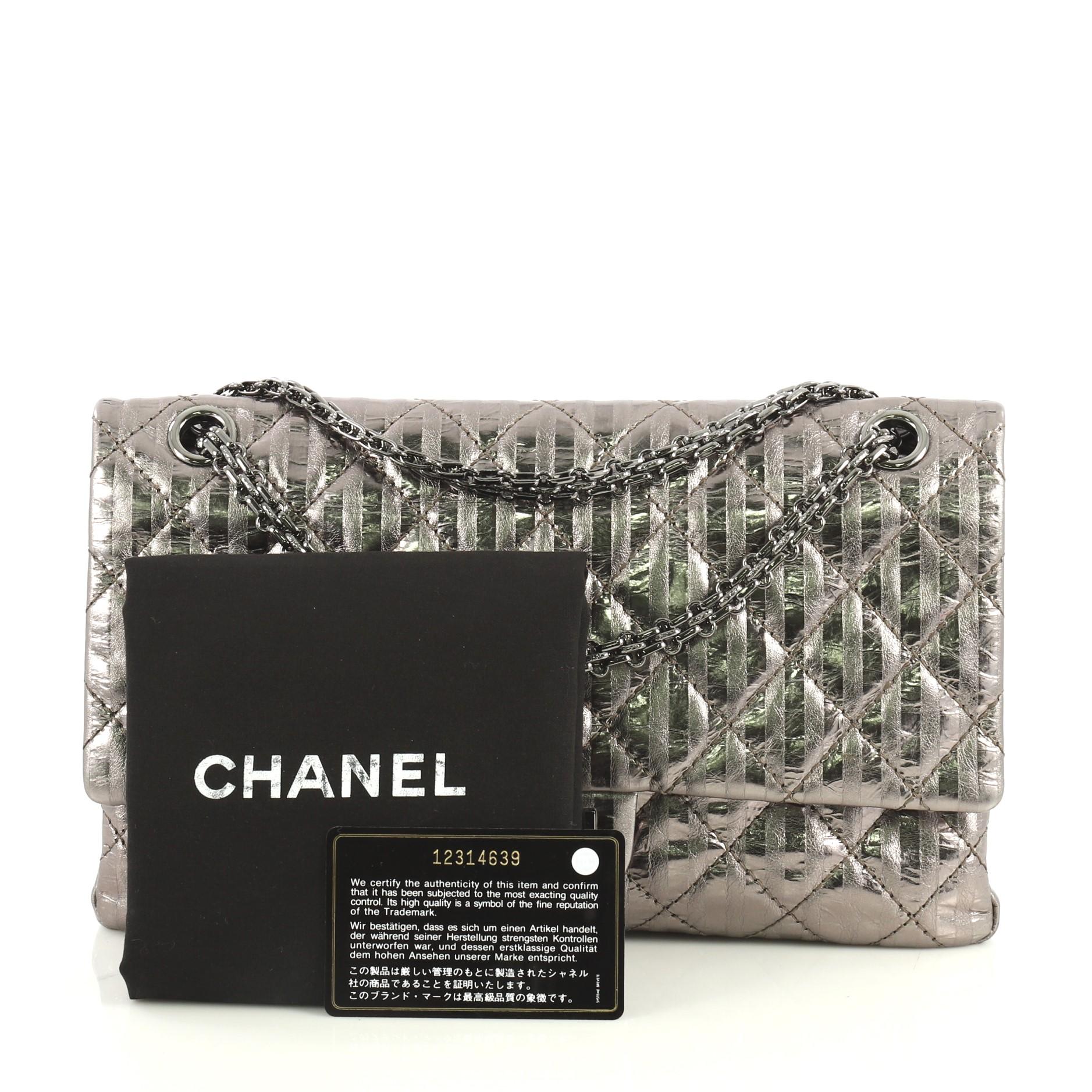 This Chanel Rayures Reissue 2.55 Handbag Quilted Calfskin 225, crafted from silver quilted calfskin leather, features reissue chain link strap and gunmetal-tone hardware. Its mademoiselle turn-lock closure opens to a dark gray metallic leather with