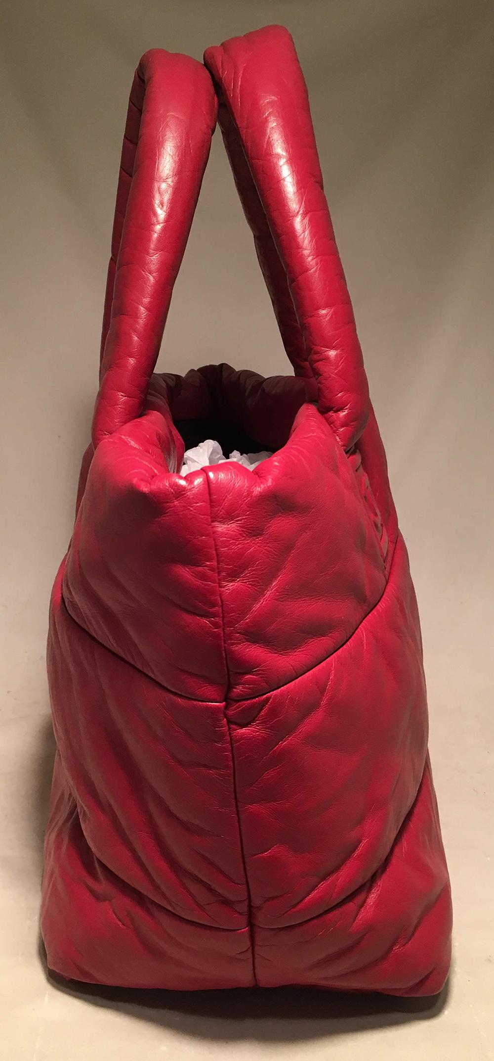 Chanel Red and Navy Puffy Leather Cocoon Tote Bag in excellent condition. Red puffy leather exterior quilted in a striped pattern with CC logo quilted along bottom and at an end of handles on front and back. Strap clasp closure opens to a navy blue