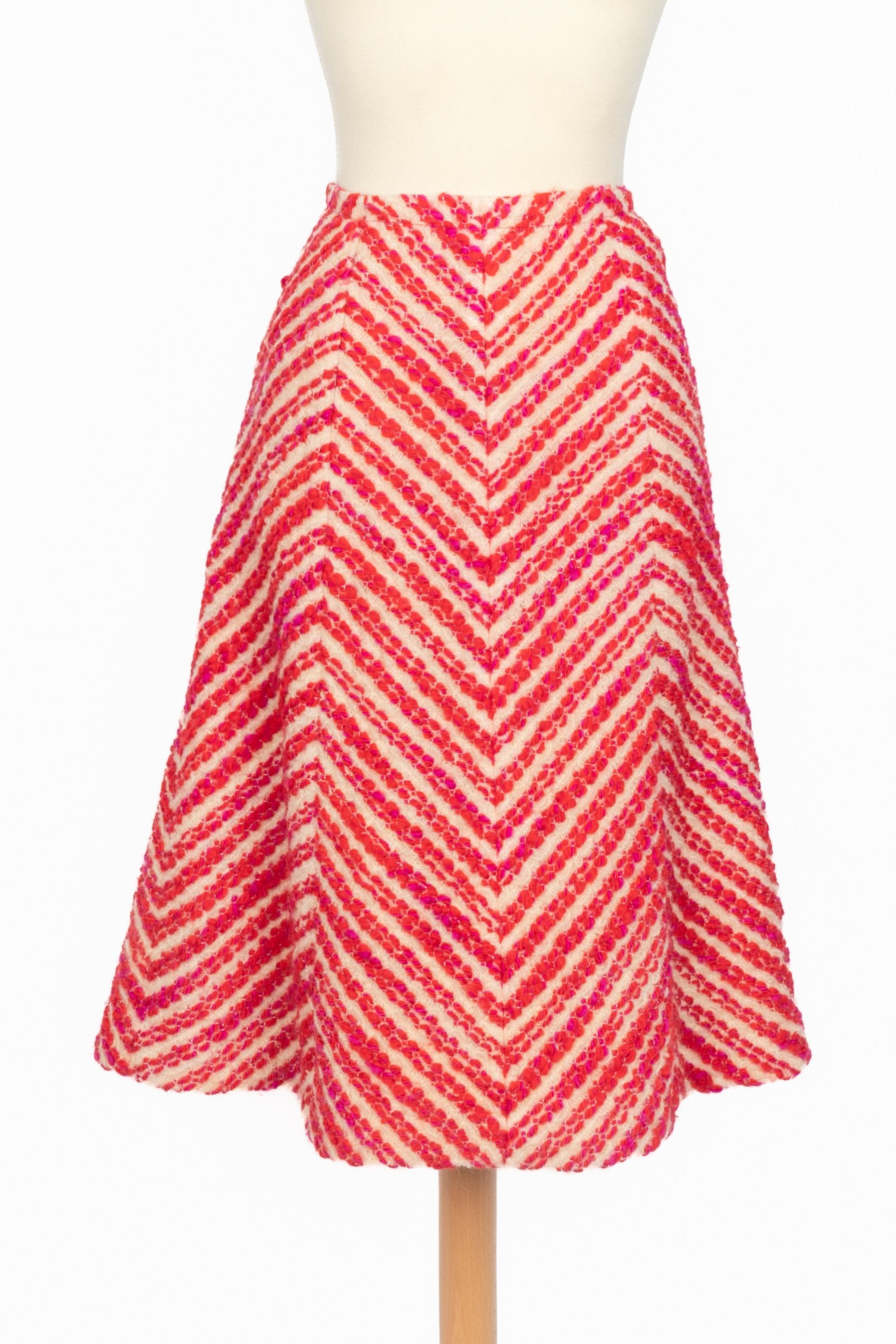 CHANEL - (Made in France) Traje-falda de lana blanca, rosa y roja con dibujo de espiga. Forro de seda. Botones de metal dorado con cabeza de león. Faltan las etiquetas de composición y talla, se ajusta a una 36FR. Pieza de los años 60. Cabe