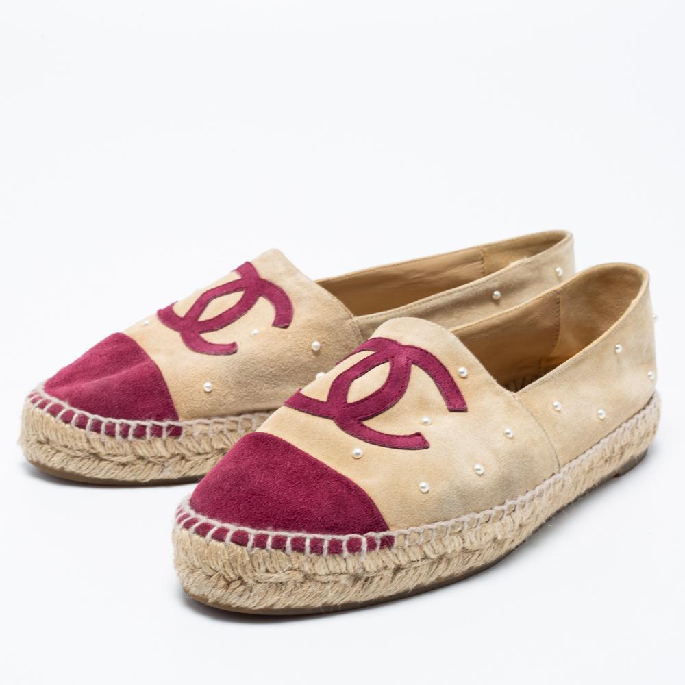 These espadrille flats from the House of Chanel are made to provide comfort and luxury to your feet. They are created using red-beige suede, with pearl accents embellishing the upper. They feature cap toes, a CC logo on the vamp, and a slip-on