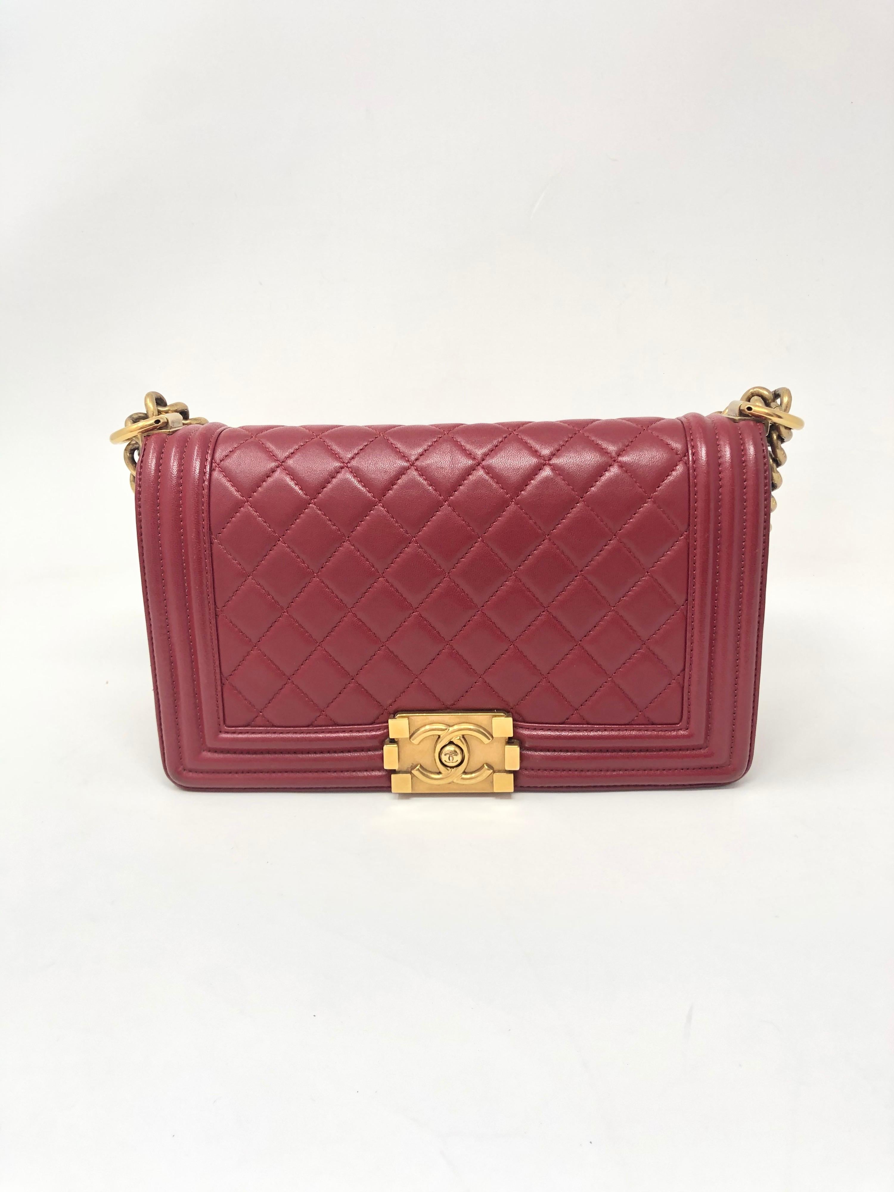 Chanel Boy Red Bag Medium Size. Gold hardware. Good condition. Dark brick red lambskin leather. Can be worn crossbody or doubled as a shoulder bag. Guaranteed authentic. 