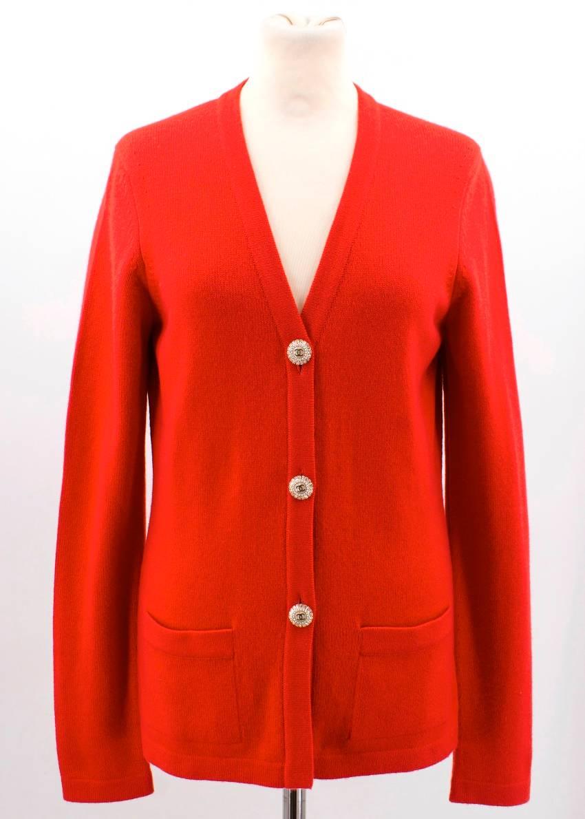 Chanel Red Cashmere Long Sleeved Front Button Cardigan featuring gold pearl embellished Chanel logo front buttons, long sleeves and two front side pockets.

Size: S/FR 38. US Size: 6/S. 
Fabric: 100% cashmere
Condition: Never worn without tags.