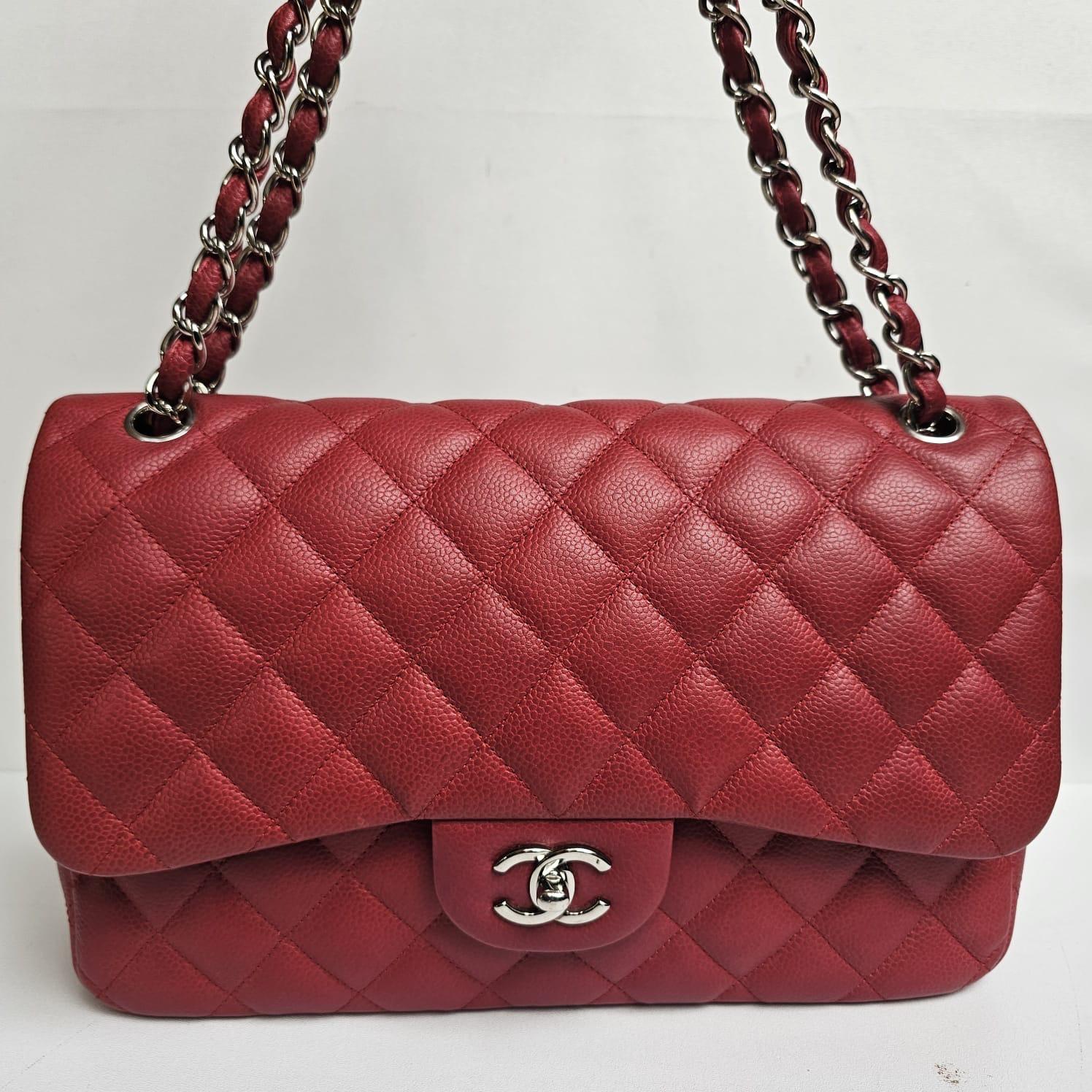 Clásico bolso Chanel Jumbo Flap en rojo caviar con herrajes plateados. En general, en buen estado, con pequeños retoques en las esquinas y en el bolsillo trasero. Serie nº 14. Viene sólo con su holo y la bolsa para el polvo.