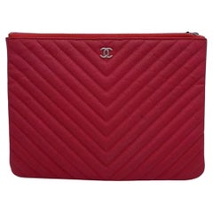 Sac à main Clouch moyen « O-Case » en cuir Caviar matelassé à motif chevron rouge Chanel, avec lettrine « H » argentée