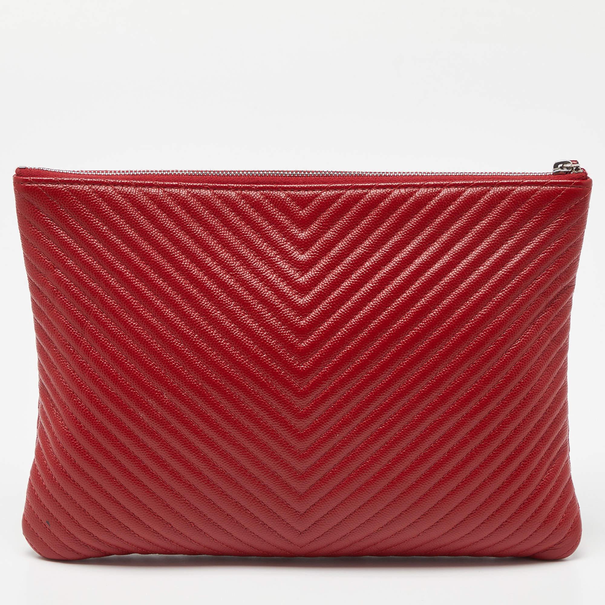 The Chanel O'Case Pouch is a luxurious accessory featuring the iconic chevron pattern. Crafted from high-quality caviar leather in a vibrant red hue, this medium-sized pouch combines elegance with practicality, making it an ideal statement piece for