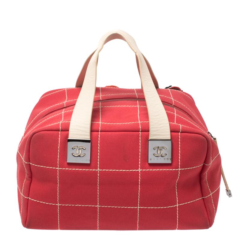 This Chanel red Boston bag is simply gorgeous! It has been beautifully crafted from canvas and designed in their signature Chocolate Bar quilt with details like 5, the CC logo and cute appliques on the front. The bag also hosts a well-sized fabric