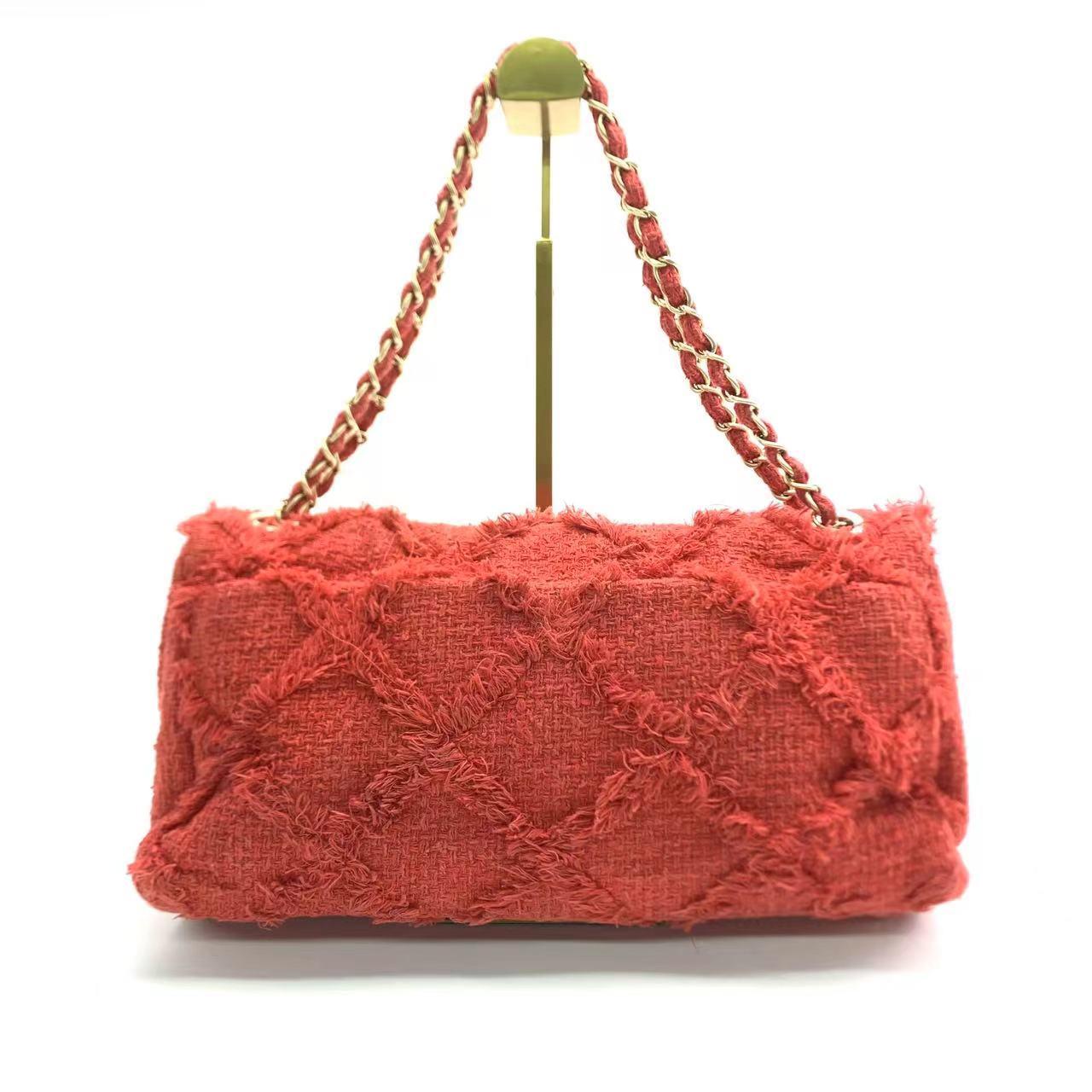 Unleash your inner boldness with the Chanel Red Diamond Stitch Tweed Maxi Nature Flap Bag. This posh and elegant bag is crafted from tweed and adorned with the signature diamond pattern, making it a must-have for parties. Featuring the iconic CC