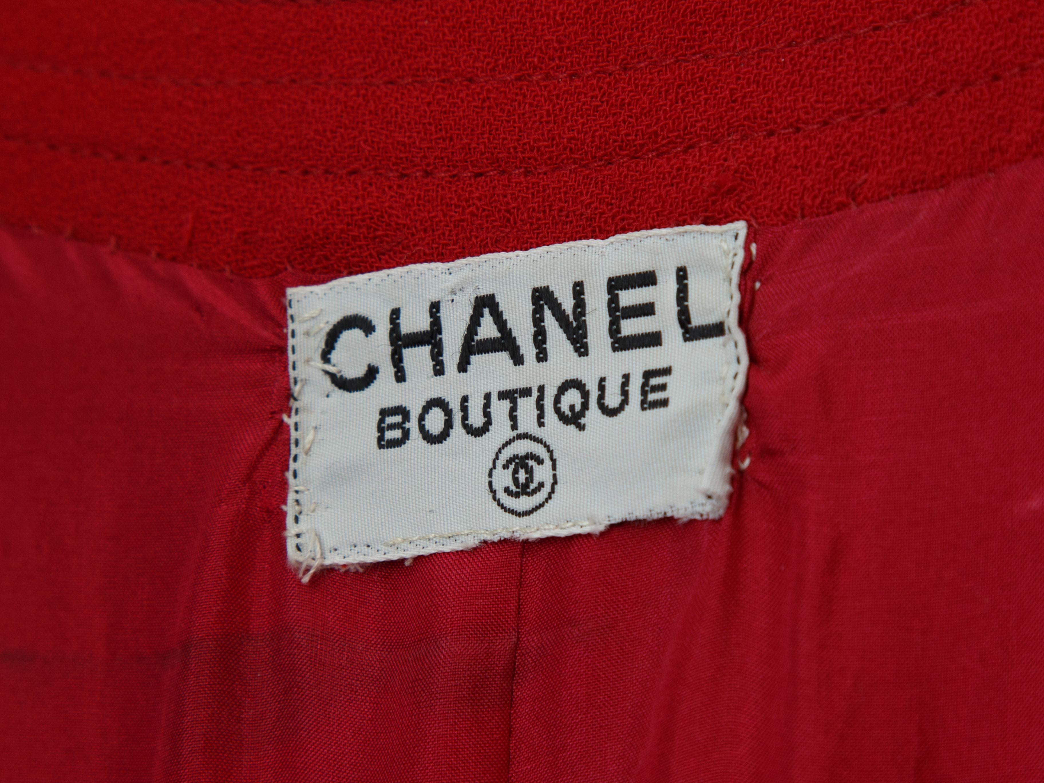 Product details:  Vintage red double-breasted dress by Chanel.  Roundneck.  Long sleeves.  Single button cuffs.  Double-breasted button-front closure.  Banded waist.  Pleated skirting.  Goldtone hardware.  36