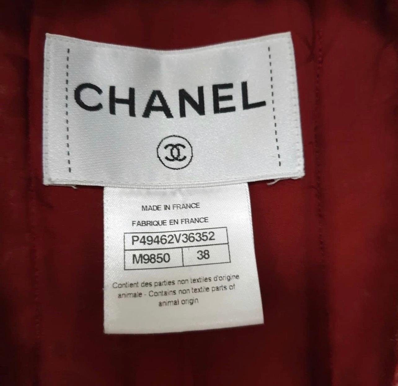 From the Paris-Dallas 2014 collection comes this Chanel Red/Ecru Tweed Jacket!
Composed of a beautiful wool blended boucle tweed, this jacket has a collarless style with a braided trim.
With chic star engraved goldtone buttons, this jacket is an