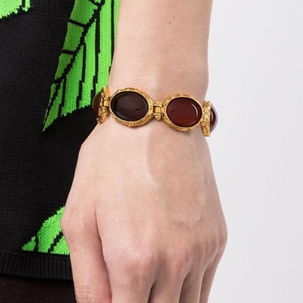 The perfect everyday essential piece, this simple yet stunning design will complement your outfit day or night. Set in gold-toned metal, this pre-owned 1996 Chanel bracelet features deep rep Gripoix glass stones. Layover the cuff of your sweater and
