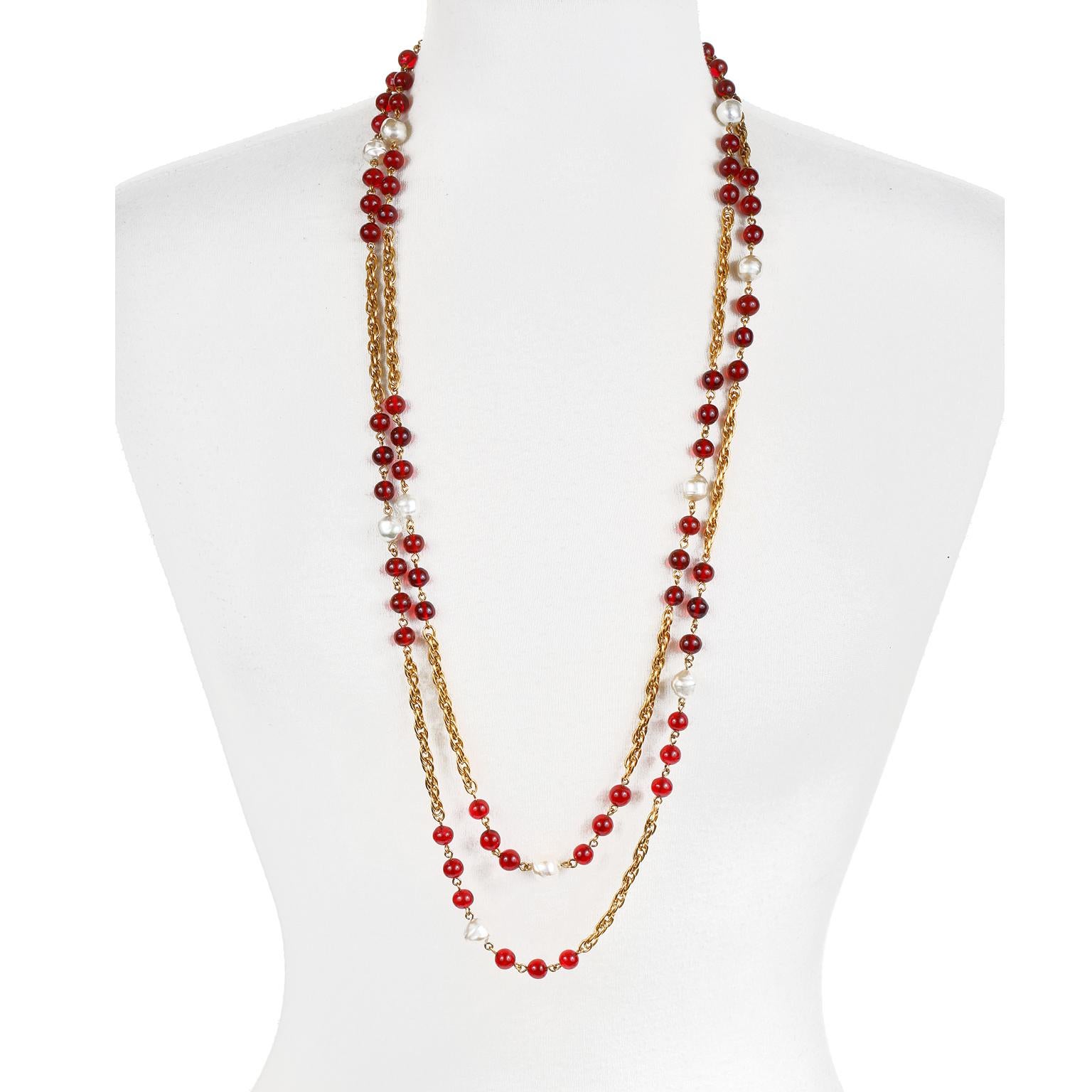 This authentic Chanel Red Gripoix and Pearl Long Necklace is in excellent vintage condition from the 1984 collection.  Red Gripoix glass beads are stationed along an extra long gold tone chain with a single Baroque faux pearl between each cluster. 
