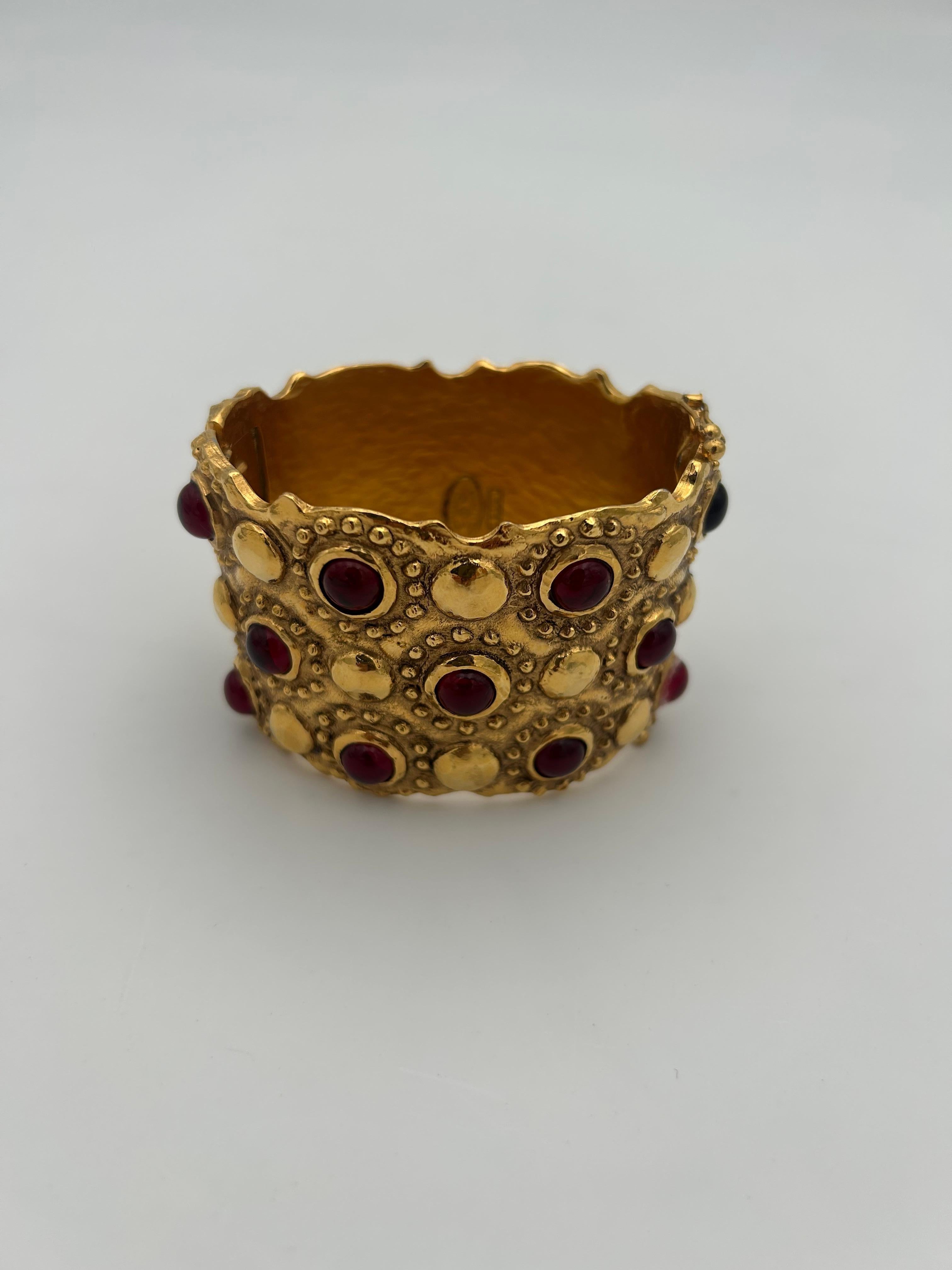 Chanel - Bracelet manchette Gripoix rouge. Ce magnifique bracelet manchette Chanel est magnifique et représente parfaitement l'adoration de la marque pour les gripoix. Le gripoix rouge apporte une touche de classe et d'originalité. 

En bon état, a