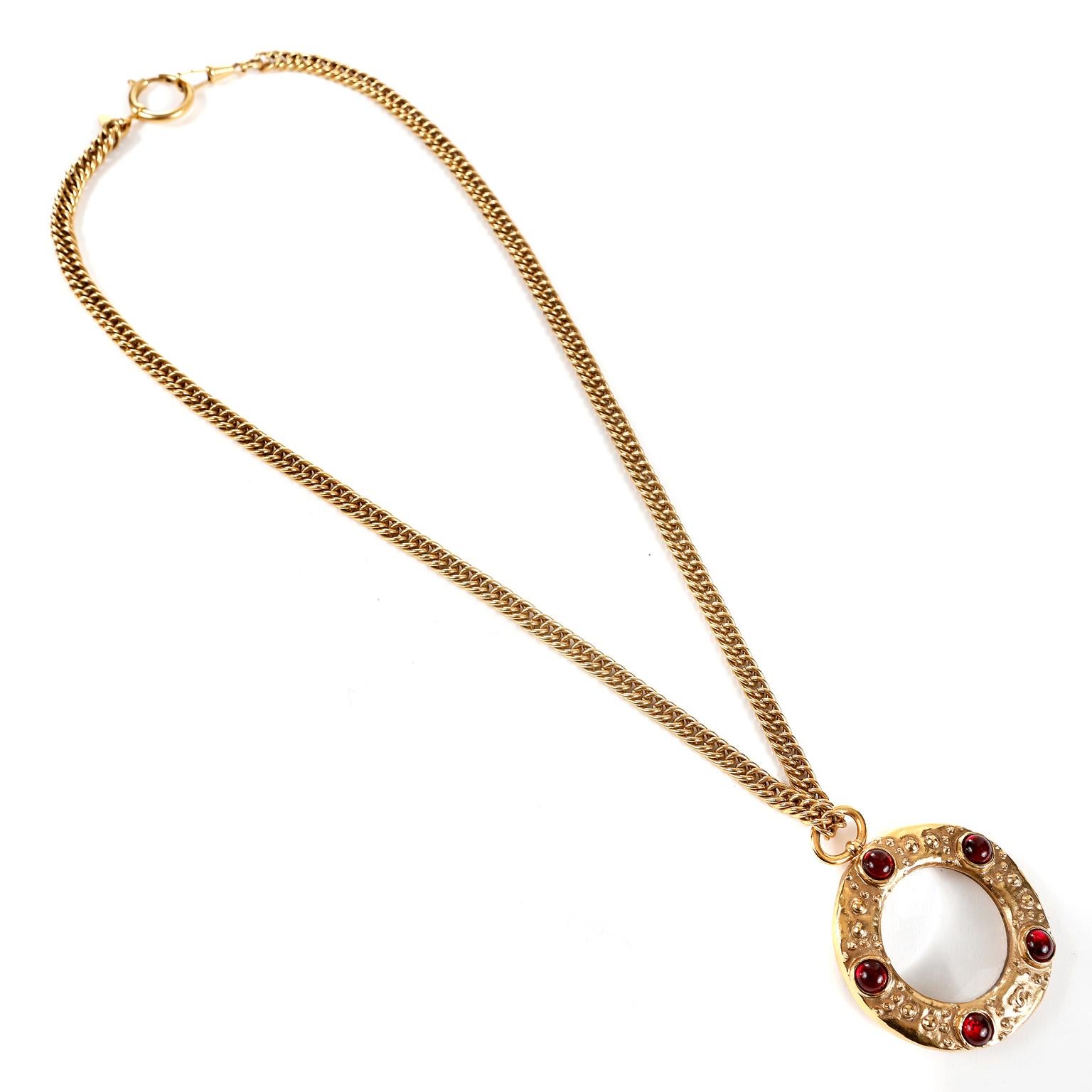 This authentic Chanel Red Gripoix Magnifier Necklace is in excellent condition from the late 1980’s.  24 karat gold plated chain with round magnifier pendant.  Gold tone embellished metal with dark red Gripoix glass stones.   Approximately 27.5