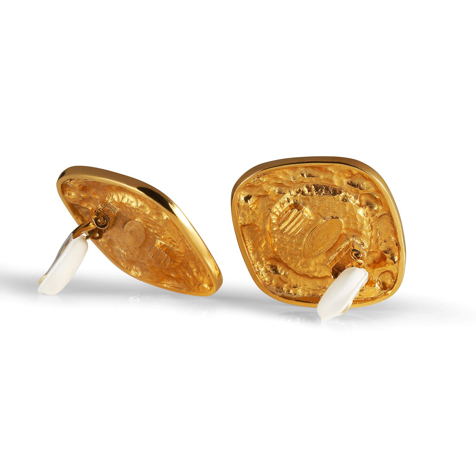 Ces authentiques boucles d'oreilles à clip Gripoix rouge de Chanel sont en très bon état et datent du début des années 1980.  Une pierre de Gripoix d'un rouge profond est entourée de volutes d'or sur un fond en forme de diamant.  Fermeture à clip. 