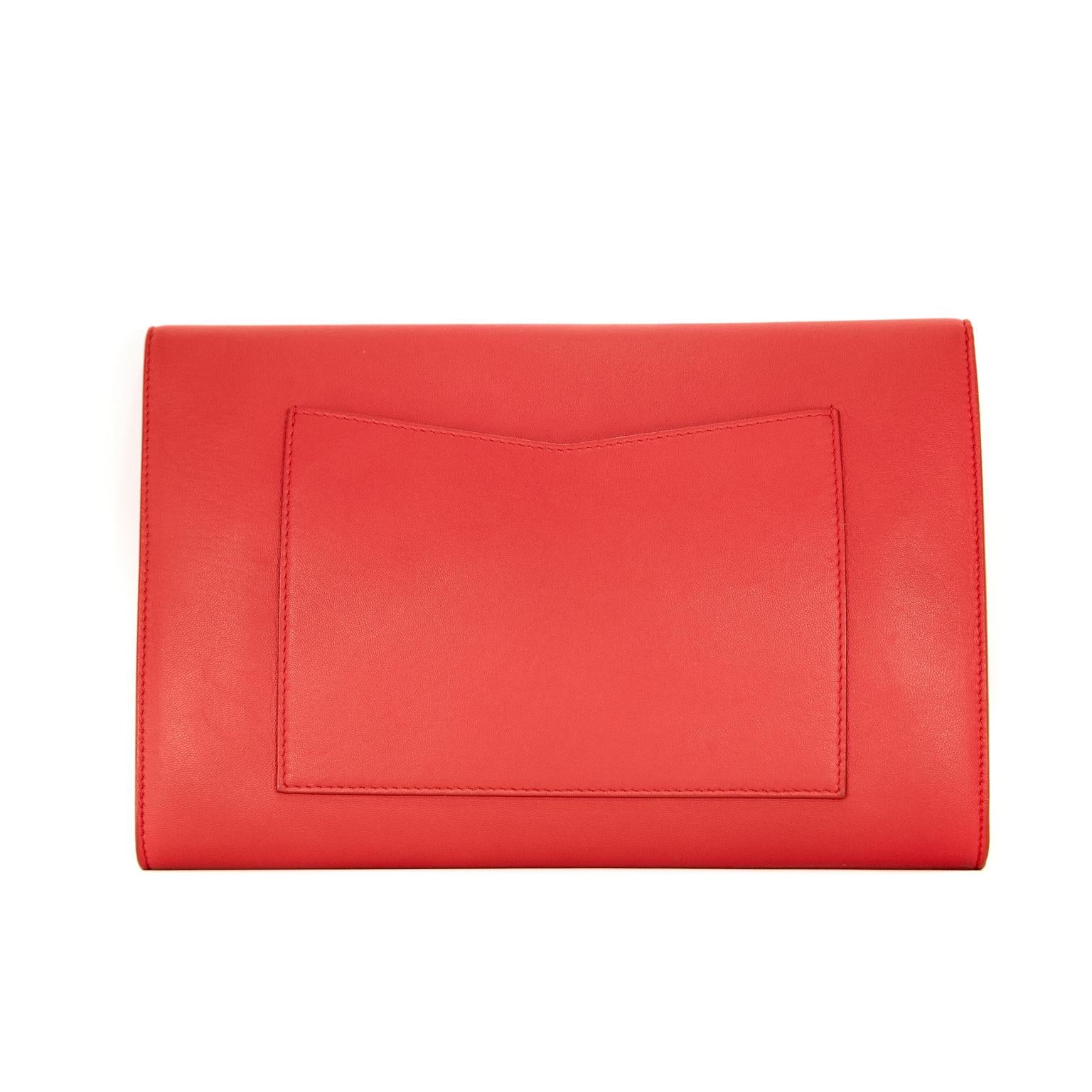 Questa autentica pochette a busta Chanel in pelle d'agnello rossa è in ottime condizioni.  Classica pochette sottile con finiture in argento e accenti a righe rosse, bianche e blu.   Prodotto in Italia.

Misure:  10