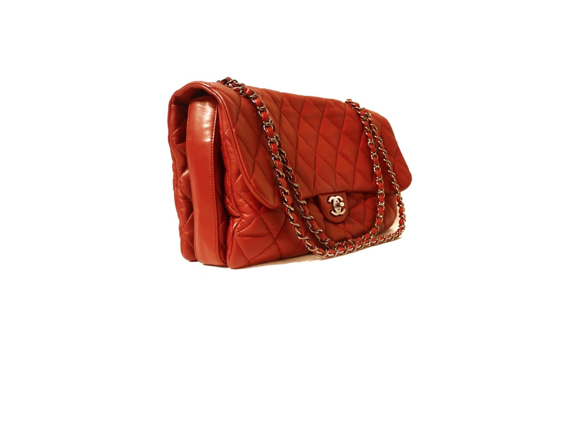 This authentic Chanel Red Lambskin Triple Accordion Flap Bag is in pristine condition.  A more yielding version of the classic flap, this is a roomy more relaxed daily shoulder bag. 
Soft red lambskin is quilted in signature Chanel diamond pattern. 