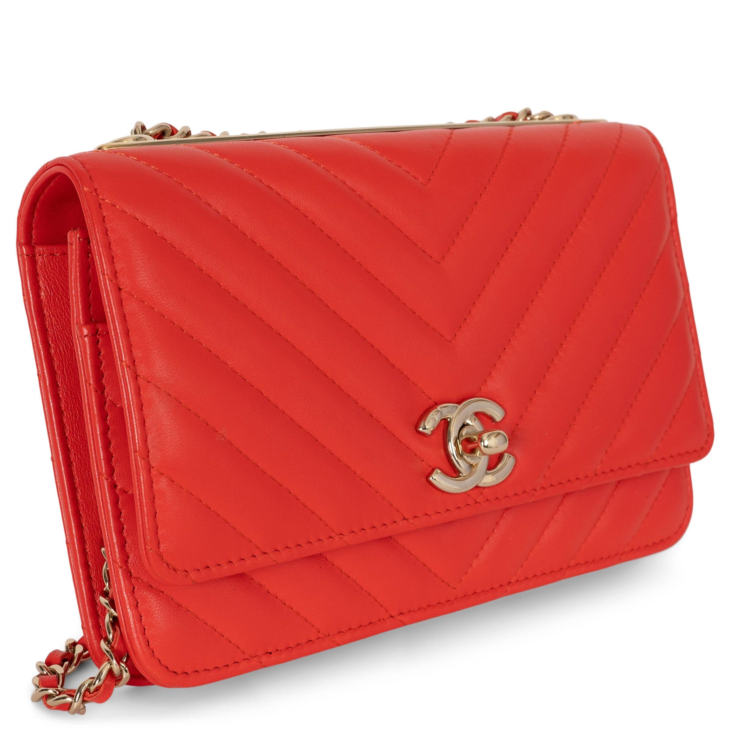 This 100% authentic Chanel Trendy CC Wallet on Chain in red chevron quilted leather is a refined balance of elegance and functionality. Featuring the signature gold-tone metal bar with logo engraving on top, it is designed with a leather interwoven