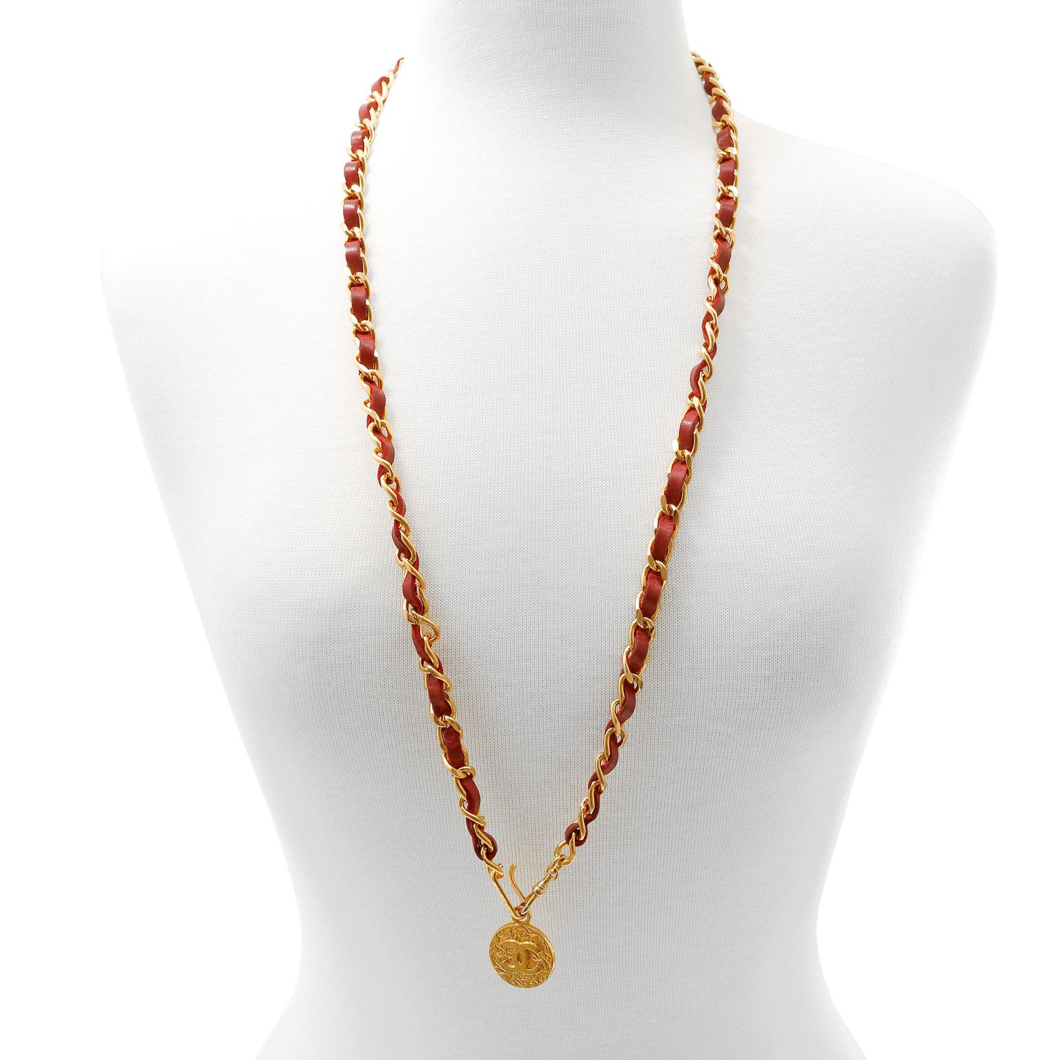 This authentic Chanel Red Leather and Chain Medallion Belt Necklace is in excellent vintage condition.  Red leather is interwoven with 24 karat gold plated chain, measuring approximately 36 inches.  A textured gold tone CC medallion dangles from the